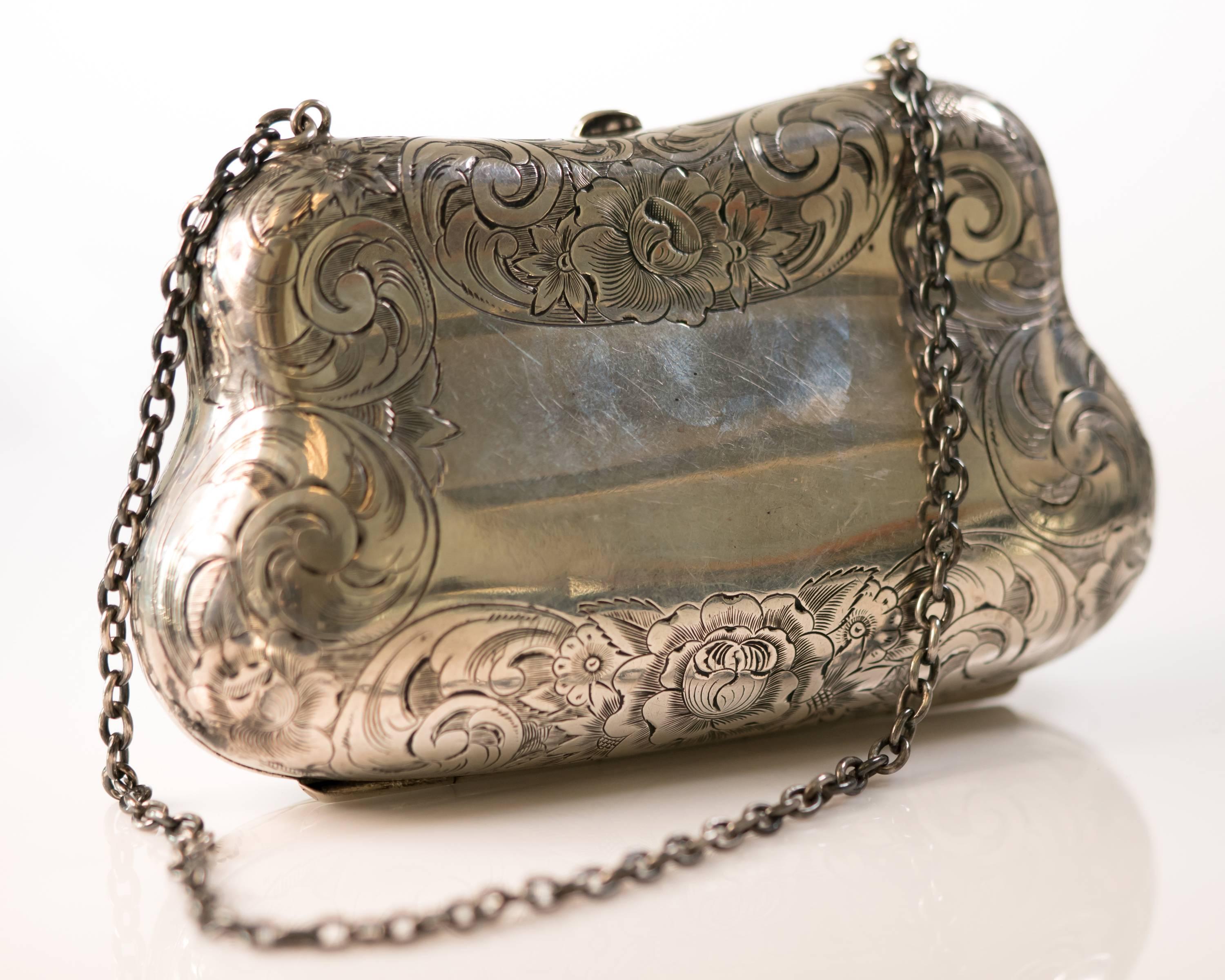 This 1940s Retro handmade Sterling Silver Clutch exterior features an engraved floral pattern on the front and back of the purse. The center front of the purse has the initials DM engraved in elegant script. The center back of the purse has an