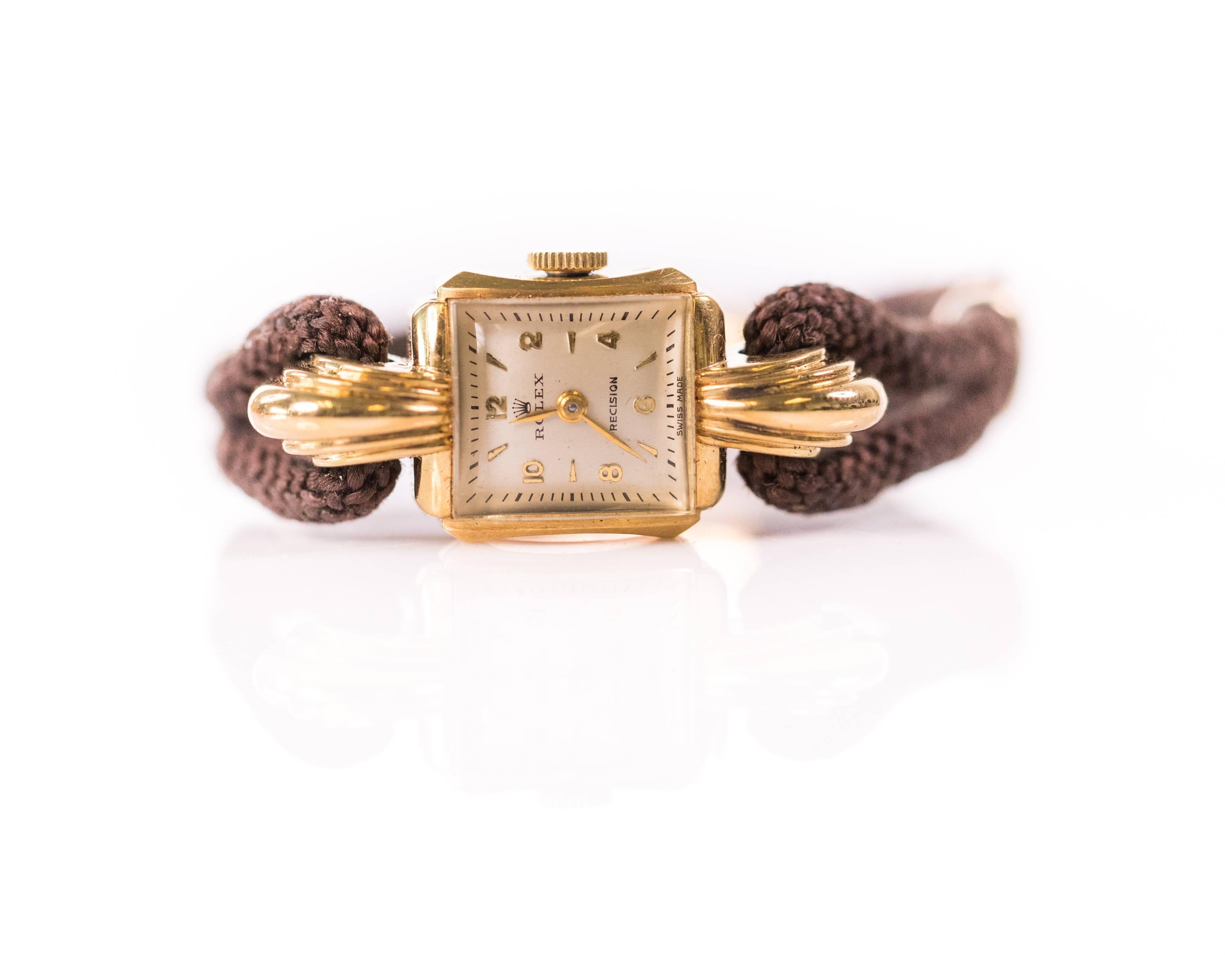 Wear this Swiss 1959 Rolex Ladies Precision 14 Karat Yellow Gold Watch anywhere, every day. It features a 14 karat yellow gold case, decorative Art Deco style lugs, ivory colored dial with gold stick and number markers, acrylic crystal and manual