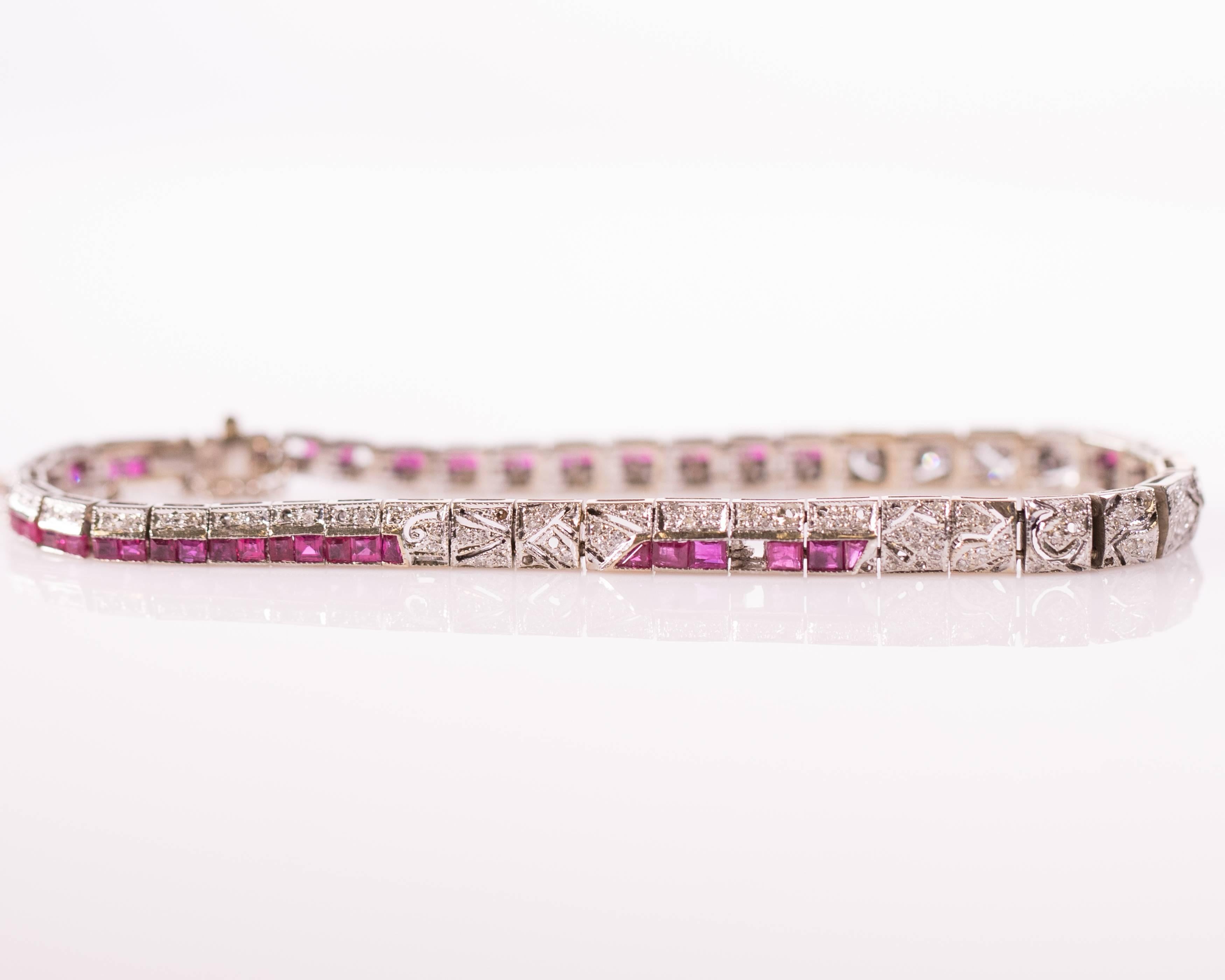 This 1925 Diamond and Ruby Bracelet exemplifies true Art Deco style and artistry. French cut Rubies and Single cut Diamonds adorn this Platinum and 18 Karat White Gold masterpiece. Ruby and diamond segments alternate with delicately patterned