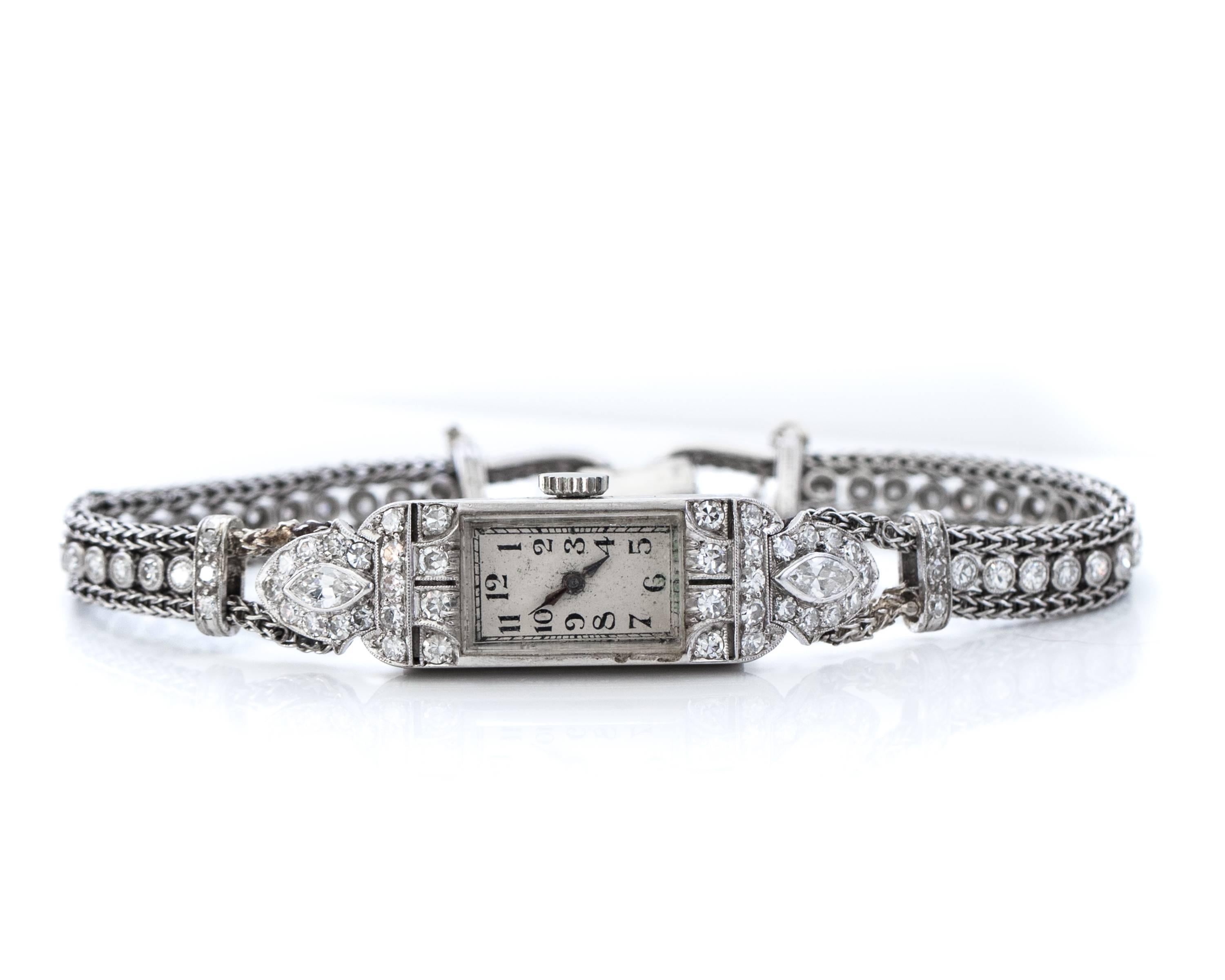 Concord Art Deco 4 cttw Diamond and Platinum Ladies Watch features a rectangle case, silvery white dial, black Arabic hour markers, hinged clasp closure with safety chain and automatic winding movement. 
The top and bottom of the bezel have 2 rows