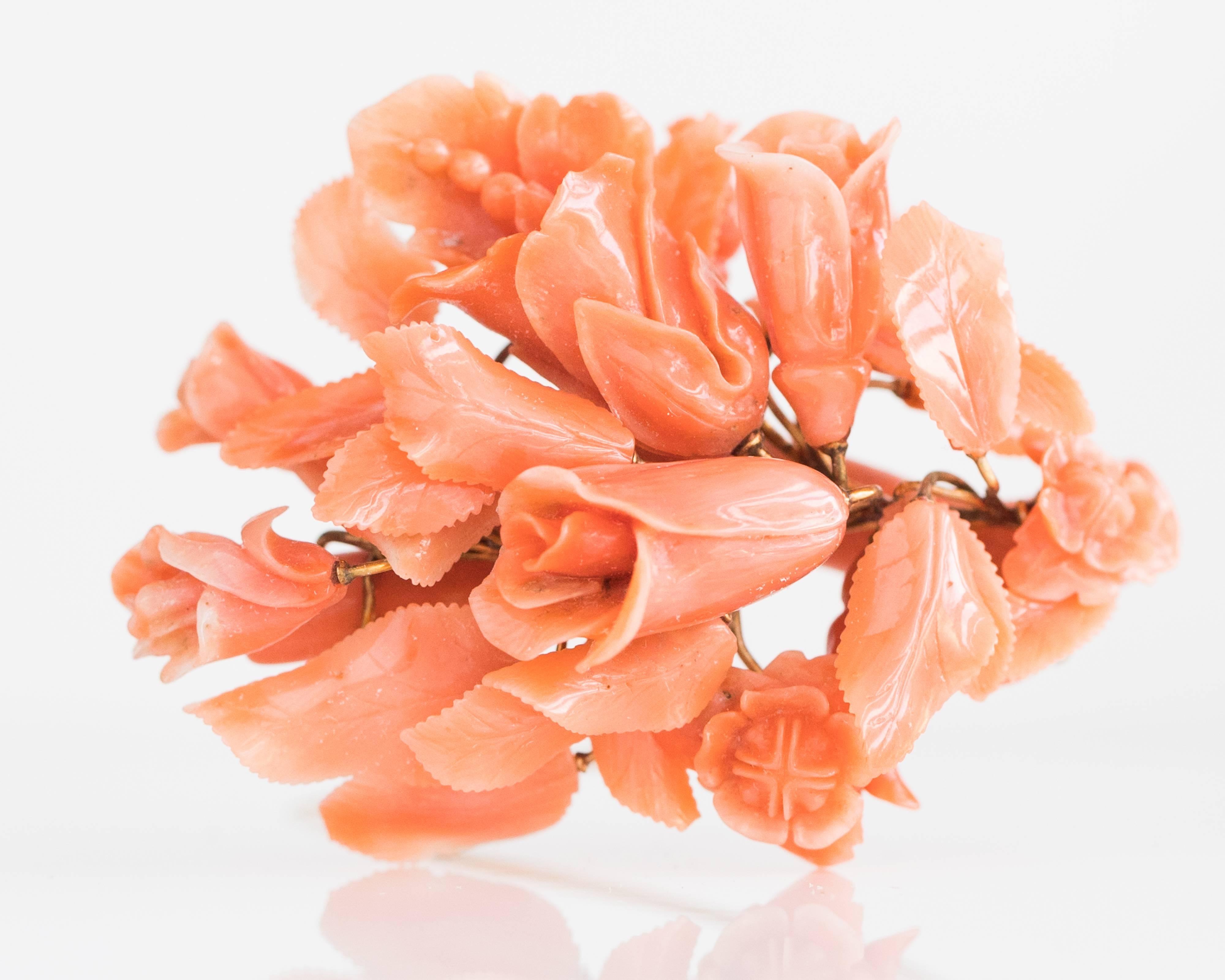 Handmade 1905 Victorian Floral Bouquet Natural Coral Brooch. This Antique pin features a 14 Karat and 9 Karat Gold mix characteristic of the time period. The Natural Coral has a high polish.

A single coral branch forms the base of this exquisite