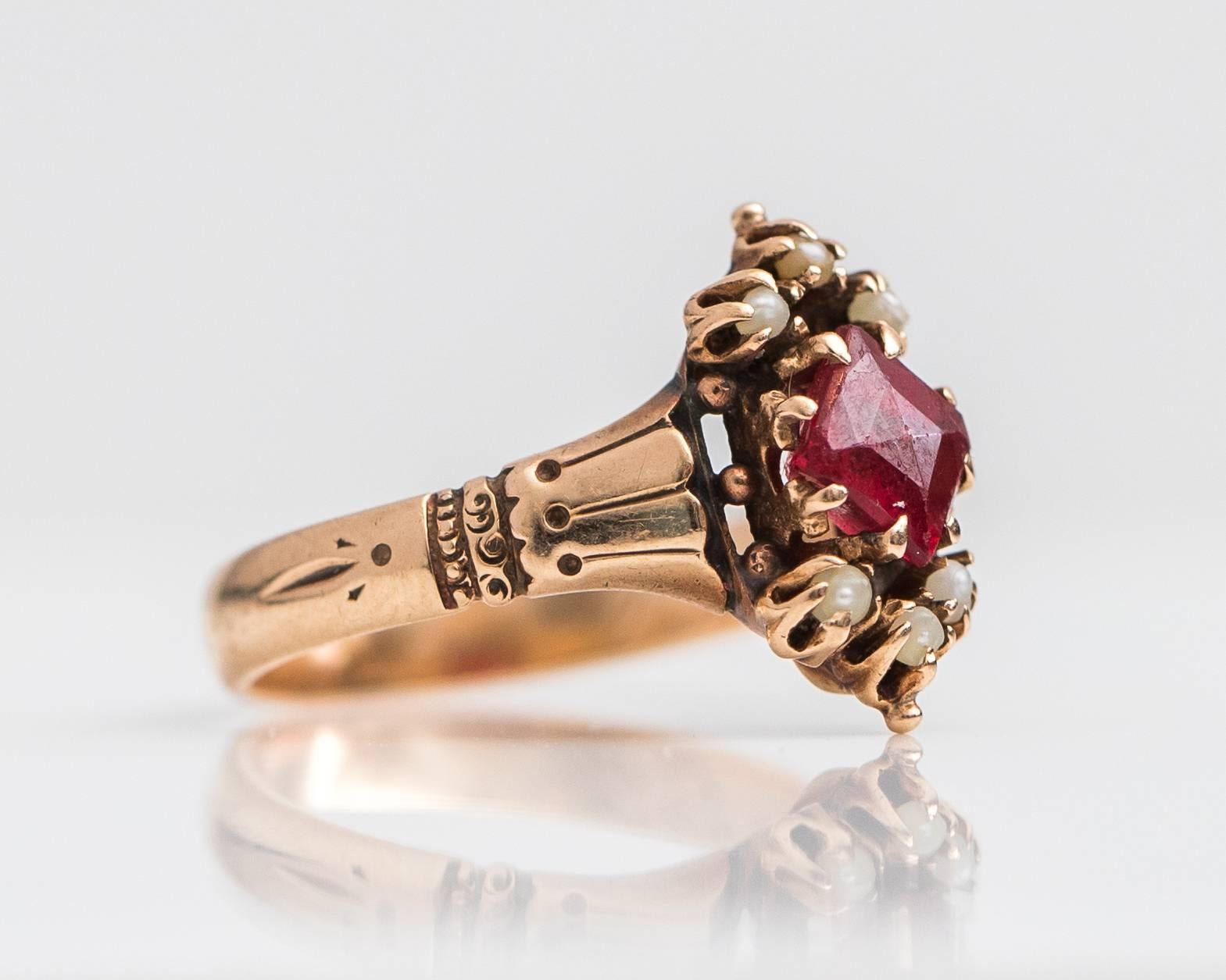 Antique 1890s Victorian Ruby and Pearl 9 Karat Yellow Gold Ring. 
Features a prong set Red Simulated Ruby with 6 Natural Seed Pearls in 9 Karat Yellow Gold. The round Ruby center stone is securely set with 8 Claw Prongs. The Natural Seed Pearls are