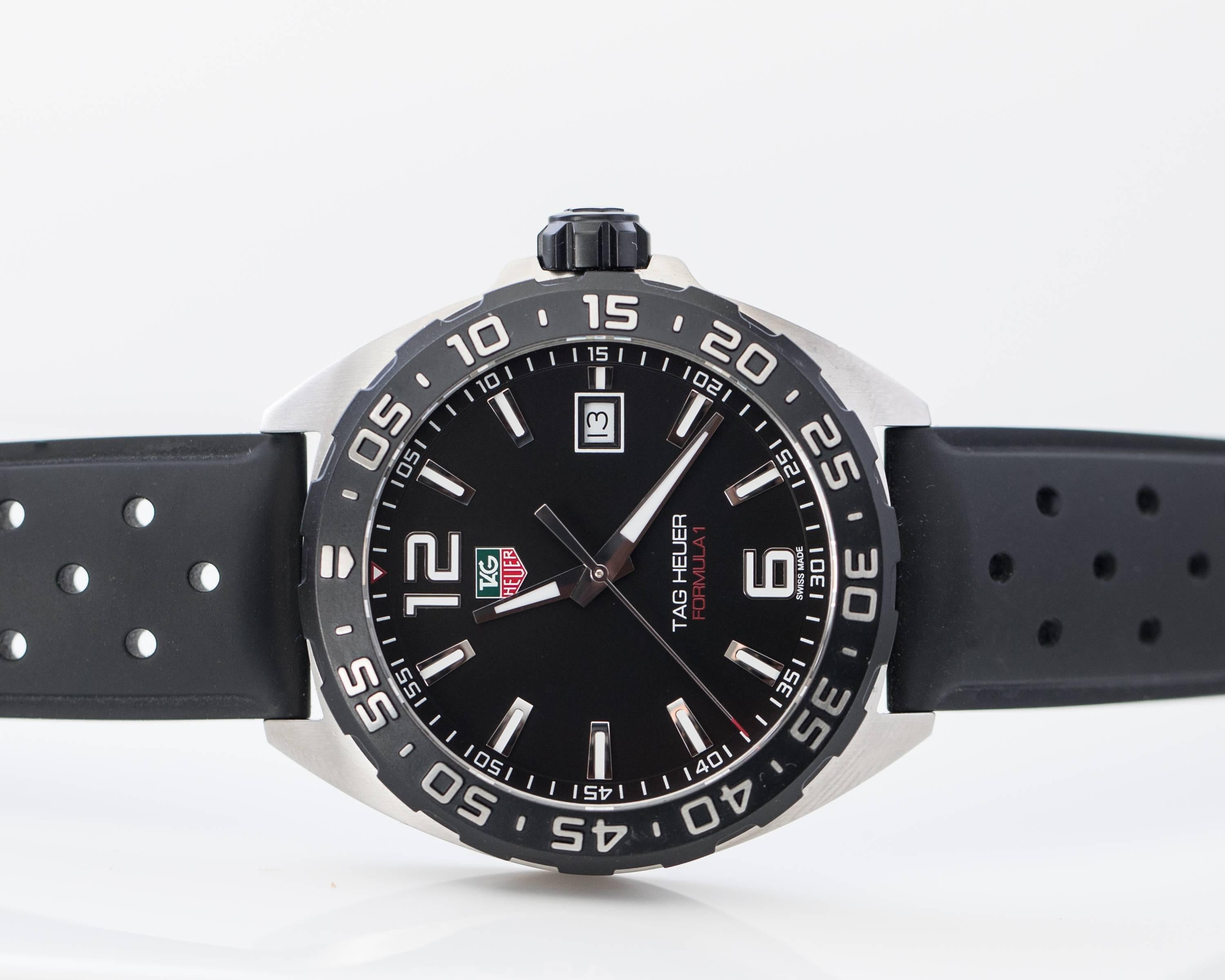 2014 Tag Heuer Formula 1 Stainless Steel 41 mm Watch with Rubber Strap. 
This Never Worn, Ultra Accurate Watch features a Black Rotating Bezel, Central Seconds Hand, Date Window at 3:00 and Black Arabic & Stick Dial with white hour markers and