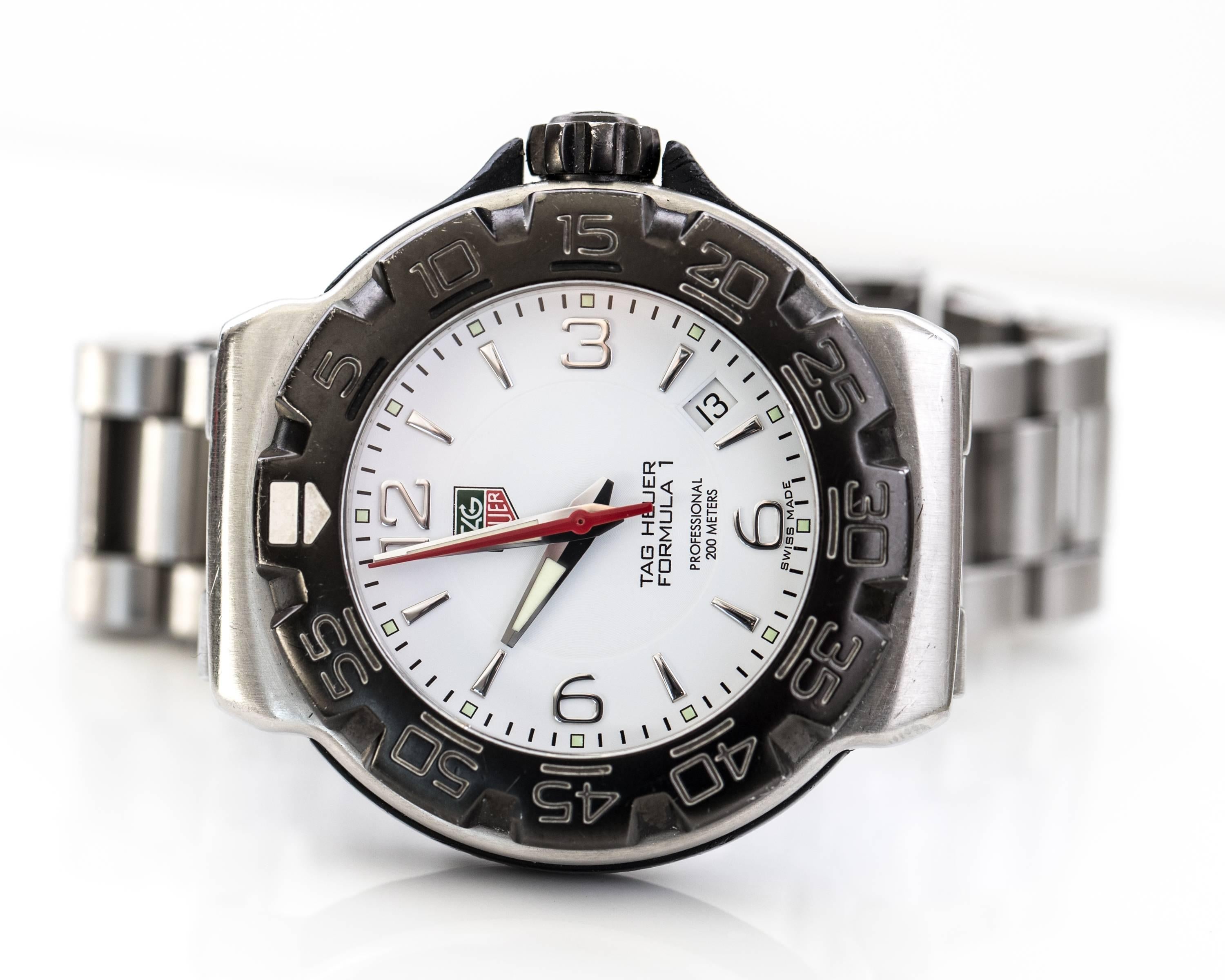 2007 Tag Heuer Formula 1 Stainless Steel 40 mm Watch with Stainless Steel Bracelet. This Ultra Accurate Watch features a White Dial with Black Rotating Bezel, Red Central Seconds Hand,  Arabic and Stick Dial with silver Hour Markers and silver and