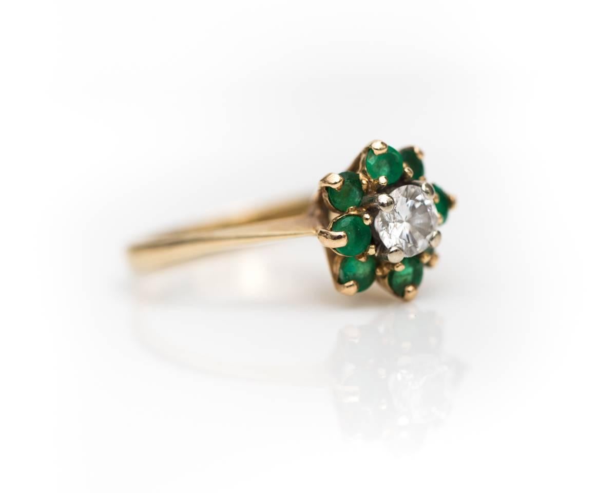 1940s Retro Diamond, Emerald and 14 Karat Yellow Gold Halo Ring with White Gold Prongs

Features a .35 carat Round Brilliant Diamond center stone surrounded by an Emerald Halo. 8 Emeralds totaling .30 carats total weight form the stunning Halo. All