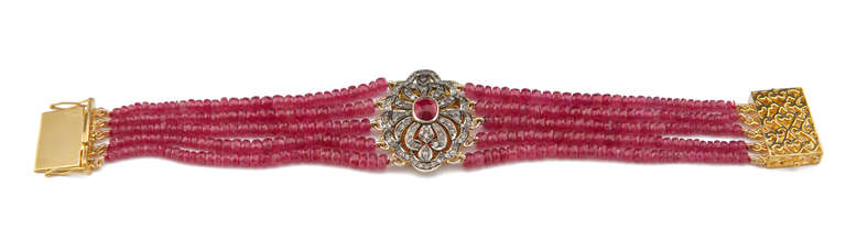 This stunning modern Multi-Strand Ruby Bead bracelet is made from 18k Yellow Gold with Black Rhodium Plate. A stunning centre stone 1.98 carat Ruby is encompassed by 1.02 carat of Diamonds and strung with 109cts of Ruby Beads. This show stopping