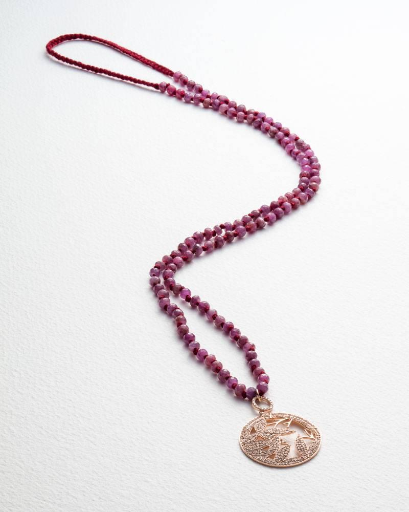 A diamond pendant  from the Jade Jagger Opium collection.
Rose gold. Ruby beads on Burgundy thread.
The thread length is 76cm.
Handmade in Jaipur, India.