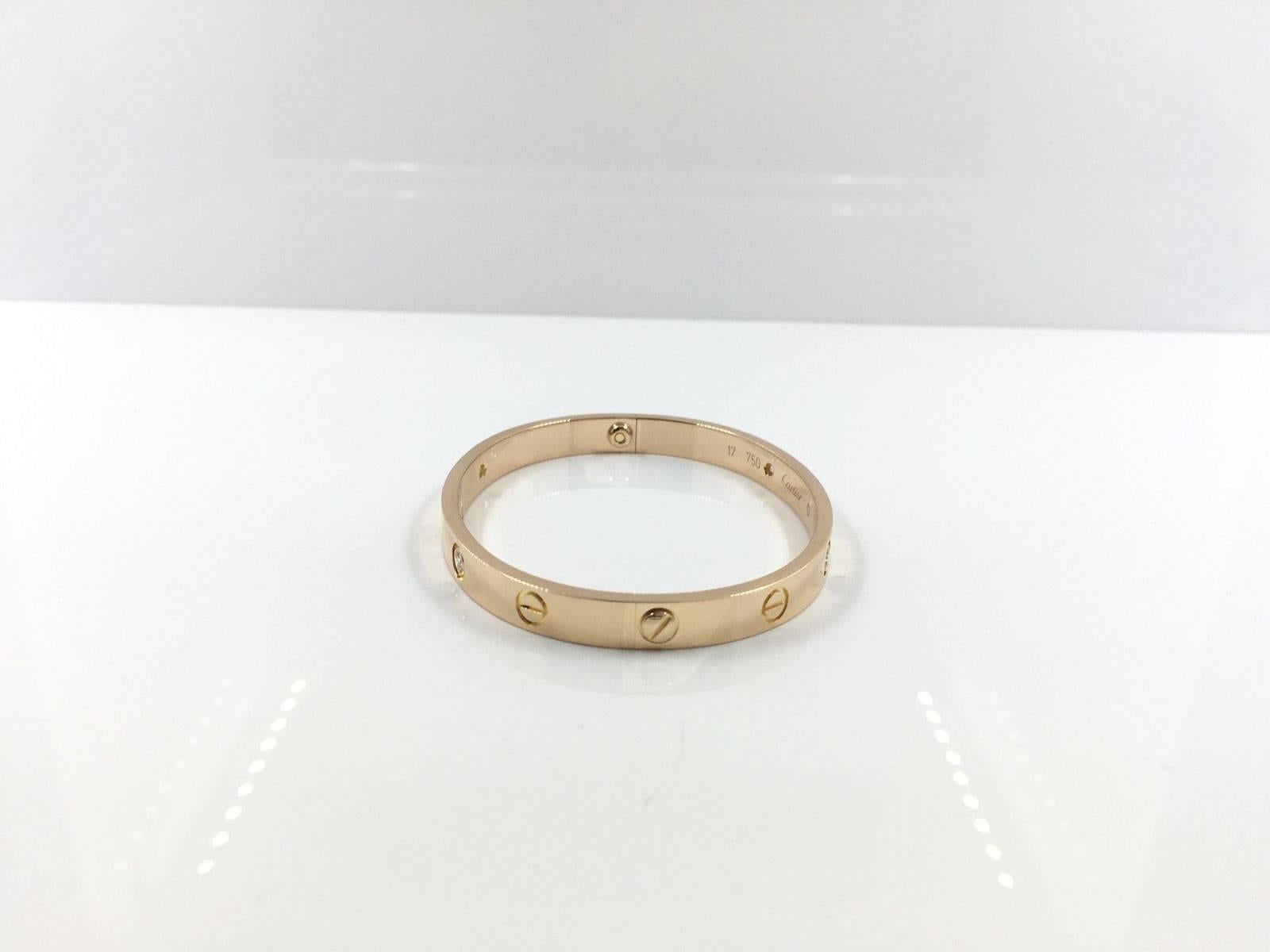This Cartier Love Bracelet, featuring 18k rose gold with 4 diamonds, is a classic, highly coveted Love bracelet by prestigious jeweler Cartier. This beautiful bracelet is a signature Cartier piece, and can be worn day and night. This bracelet was