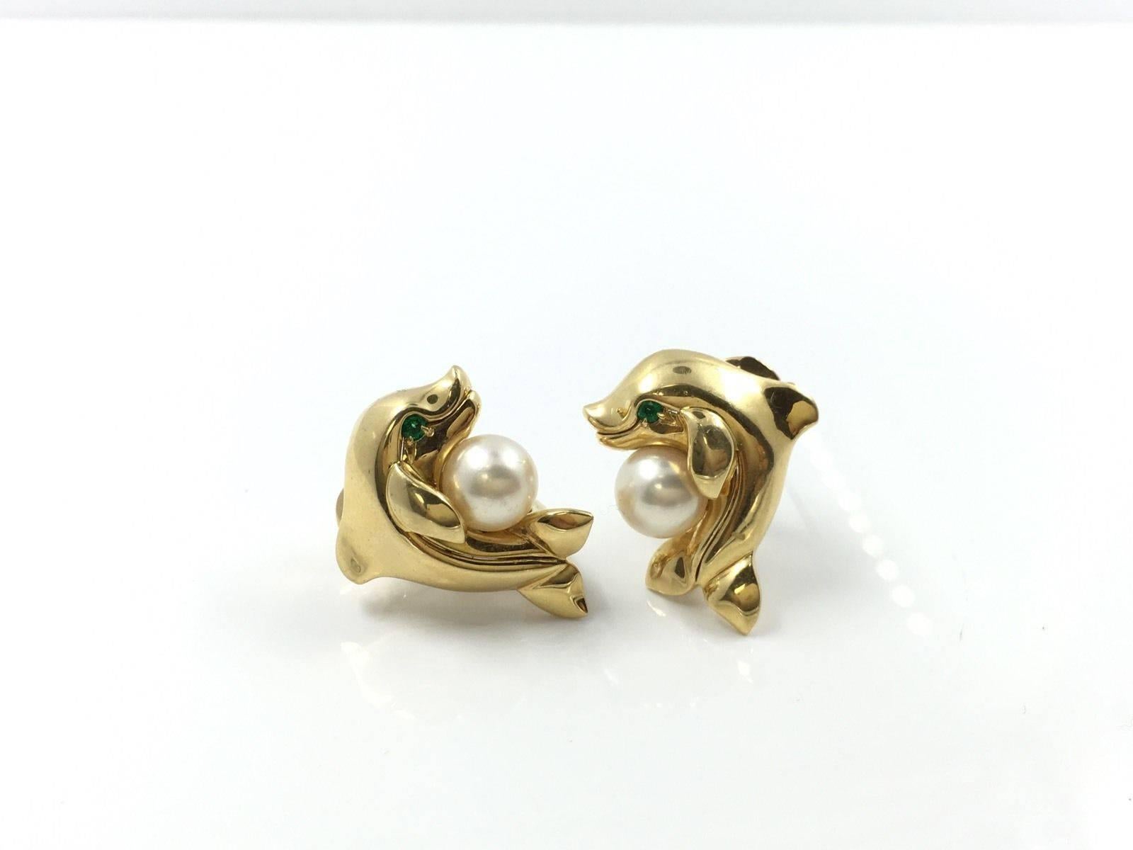 Estate Cartier 18k Gold & Pearl Dolphin Earrings

Cartier Dolphin earrings, composed of an 18k yellow gold dolphin,
 accented by a round pearl, with circular-cut emerald eye, with clip and post backs,
 numbered 711076, signed Cartier. 23mm