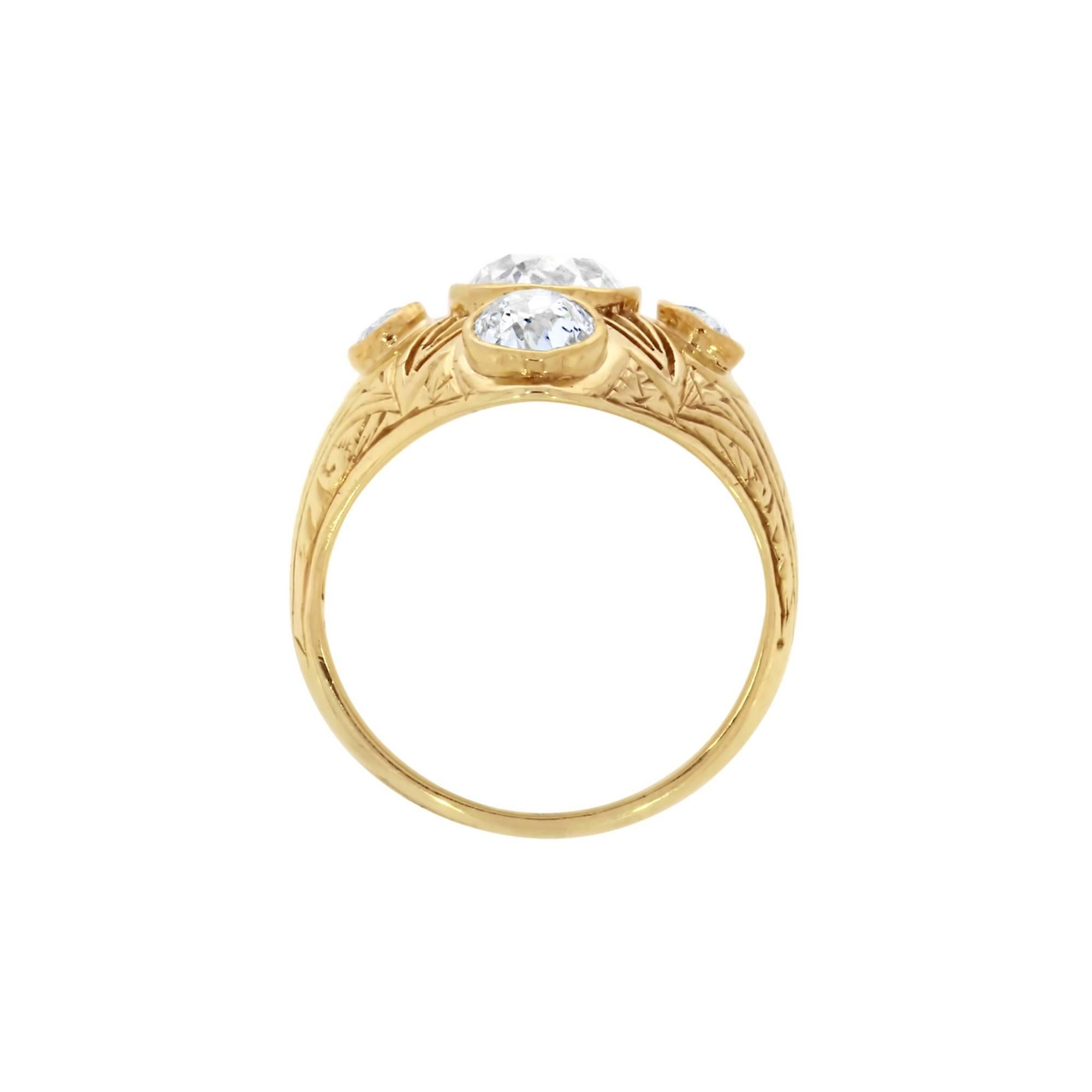 A fine example of Victorian jewellery, this yellow gold ring features at the centre of it an old cushion shaped diamond. Set around the central diamond are four smaller old cushion cut diamonds. The ring has been delicately engraved, and