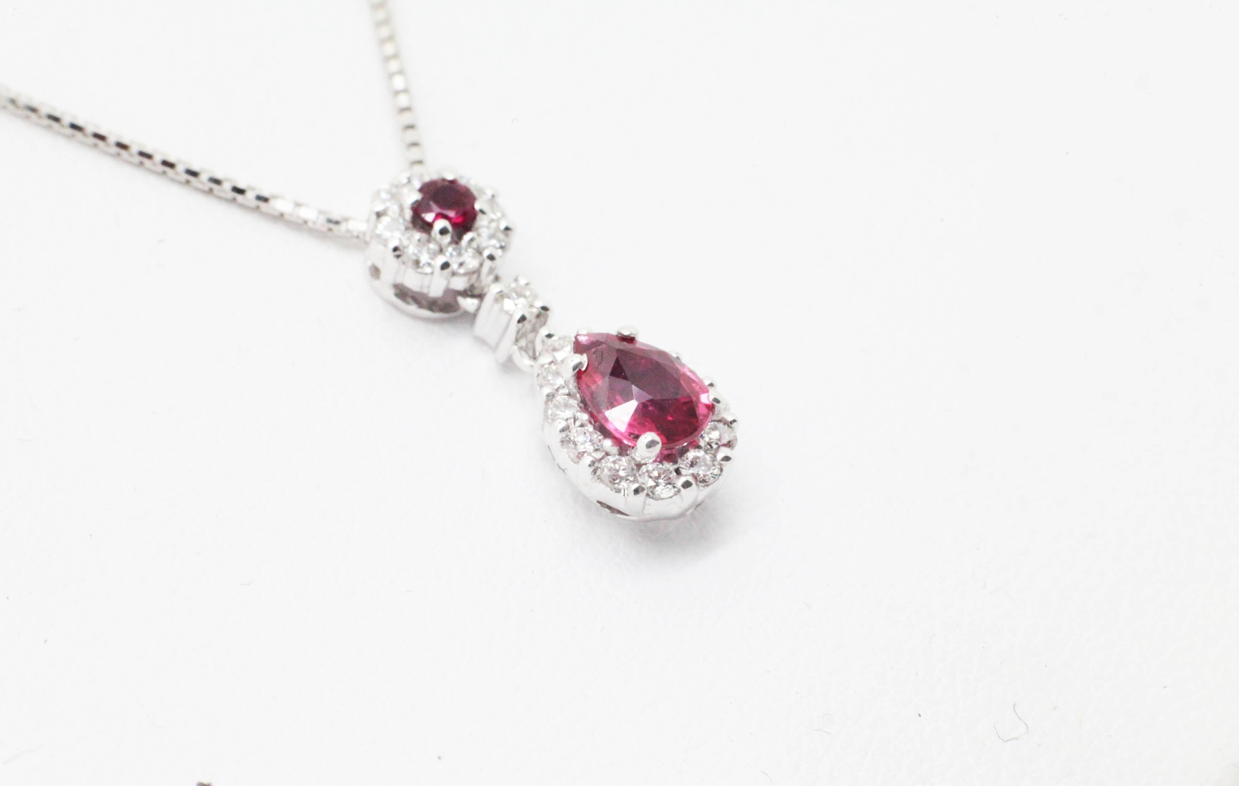 Fine piece from FERRUCCI & CO., a wonderful pear shape natural ruby and round ruby for a total carat weight of 0.56 carats, adorned by a white diamond halo of 0.30 carat weight, conceived in 18k white gold necklace made in Italy.

