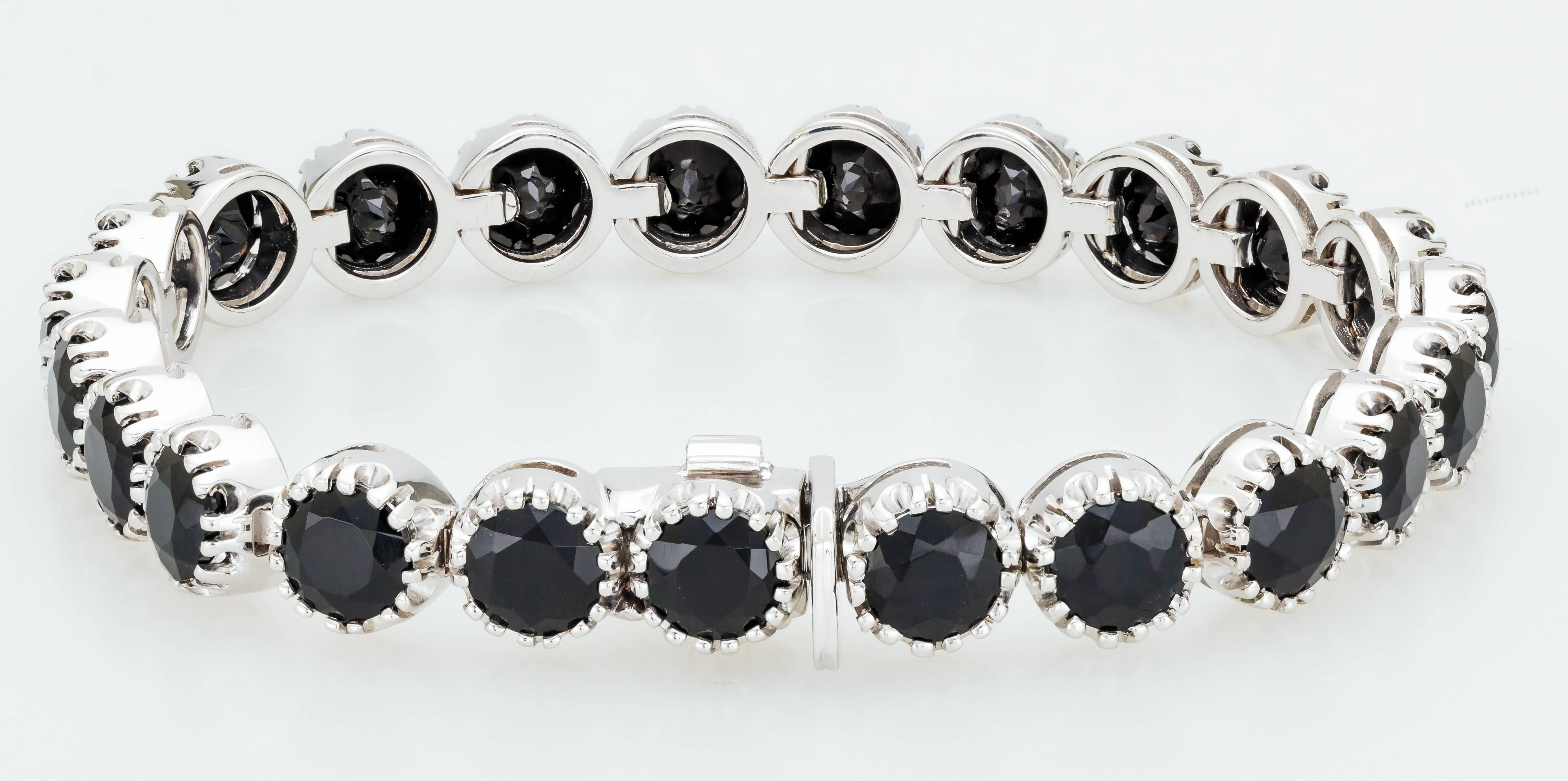 This 18K white gold Roberto Coin bracelet is set with 23 black onyx, each measuring 6mm diameter.  It also has a hidden ruby, the Roberto Coin signature. The clasp features a safety latch for added security.  The back of the clasp has the ruby and