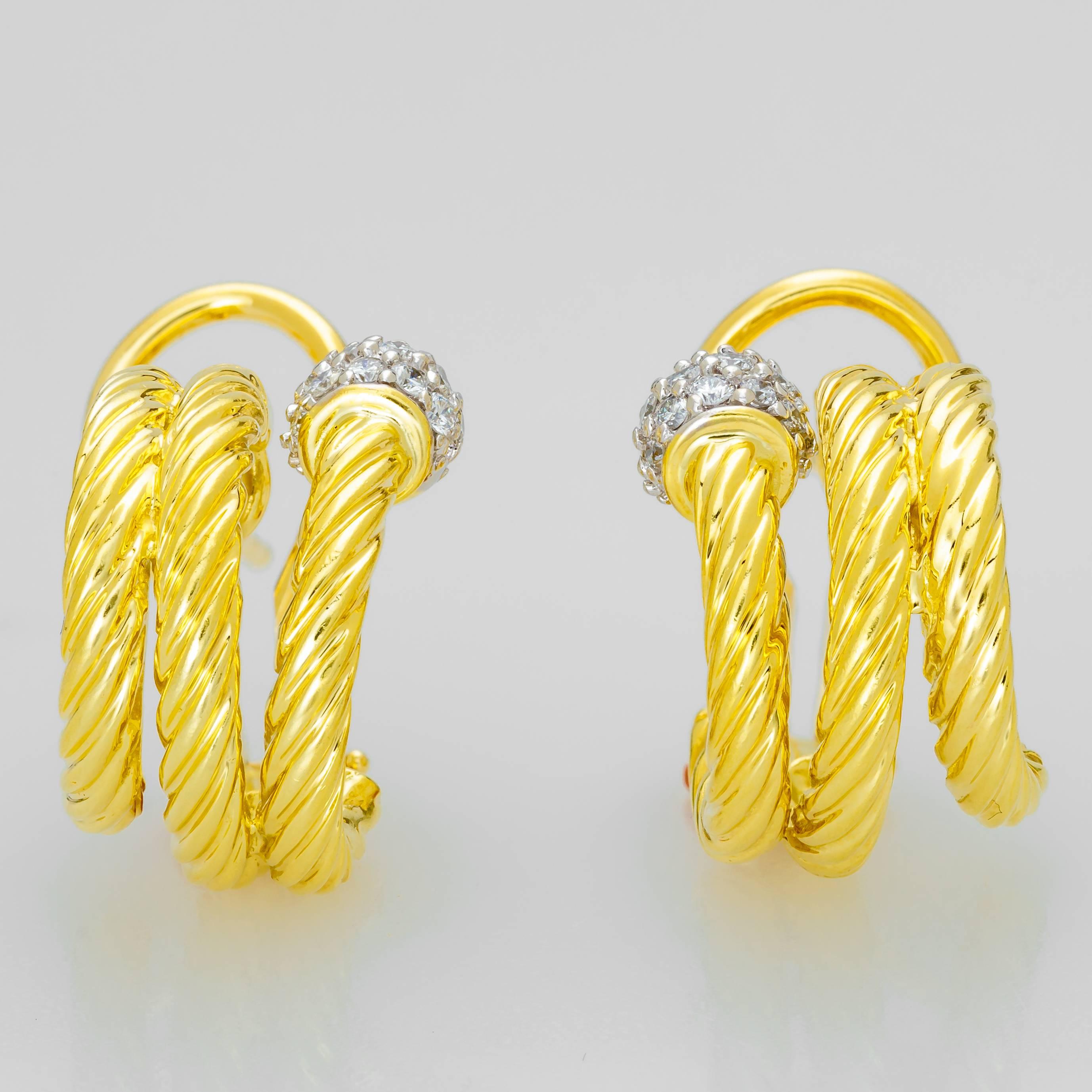 This set of David Yurman earrings feature a cable design in 18K yellow gold.  Each earring has a pave ball of 16 diamonds at the end of the curl.  They have an omega clasp on the back.  Each earring measures 17mm tall x 16mm deep x 11mm wide and