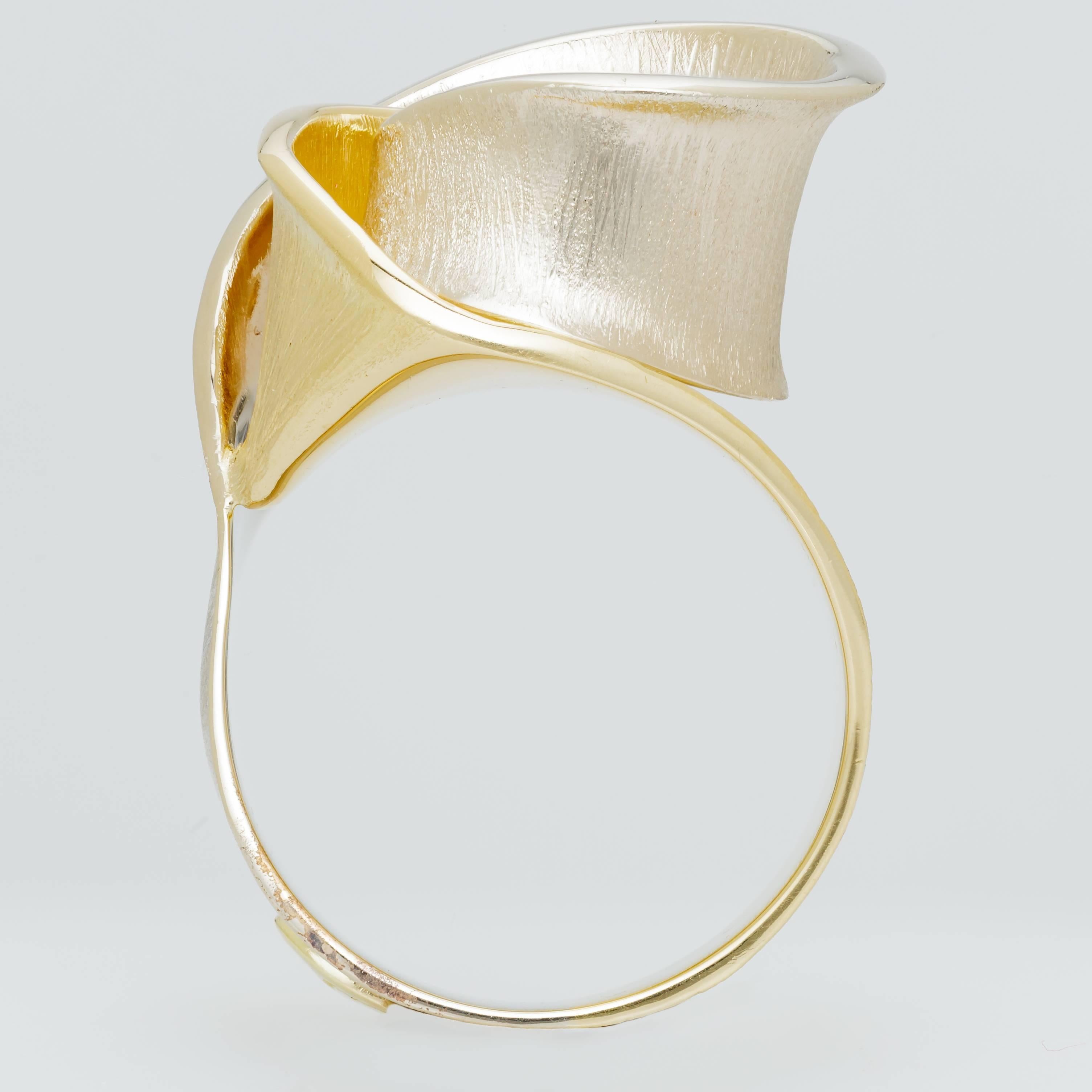 This new H. Stern ring features a fluid rose design, half in 18k yellow gold, half in 18k rose gold.  The ring fits a size 7.  Has minor marks from storage.