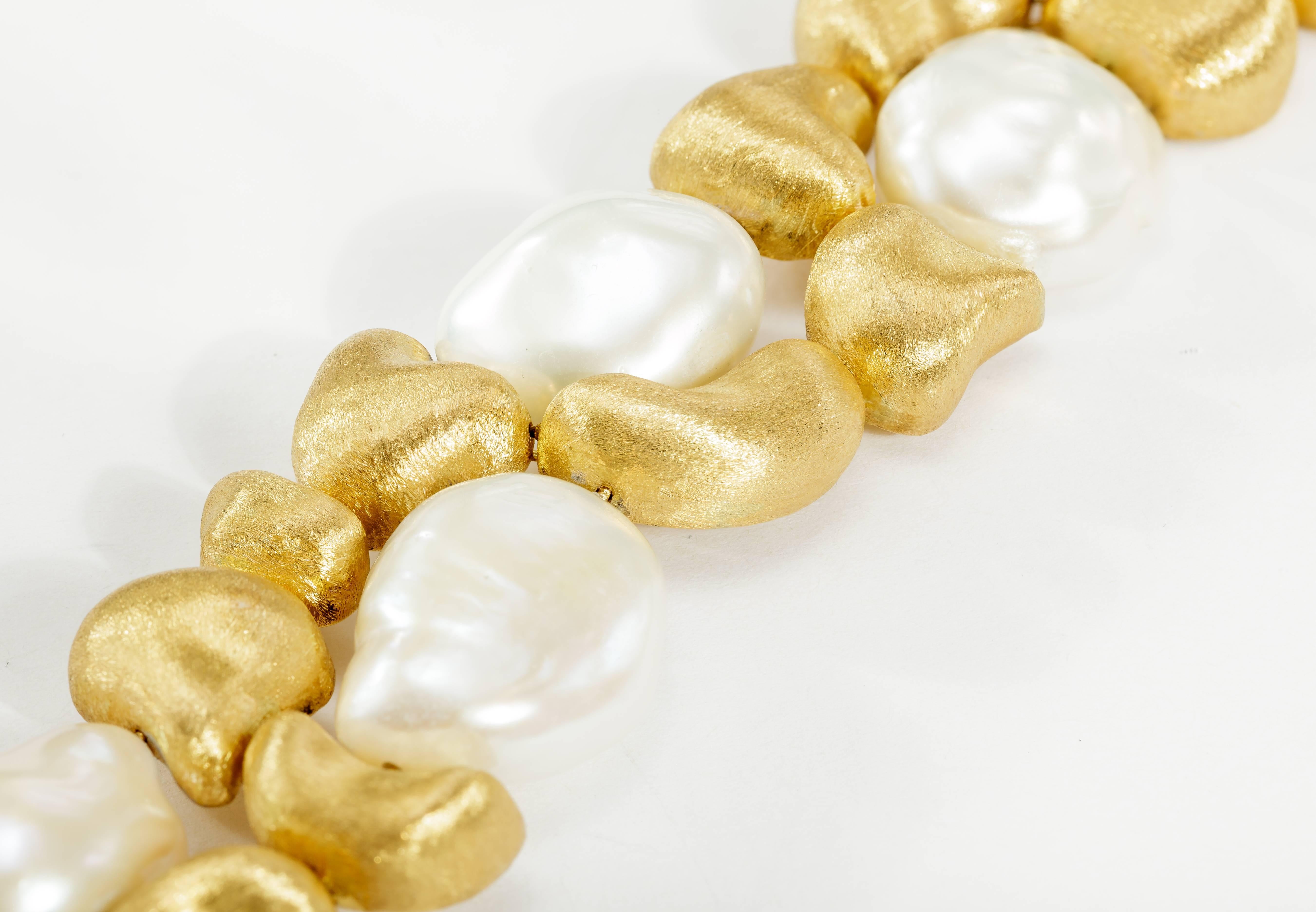 This Yvel pearl and 18k yellow gold bracelet features seven freshwater baroque pearls and yellow gold satin finish beads.  The bracelet measures 7.5 inches long.