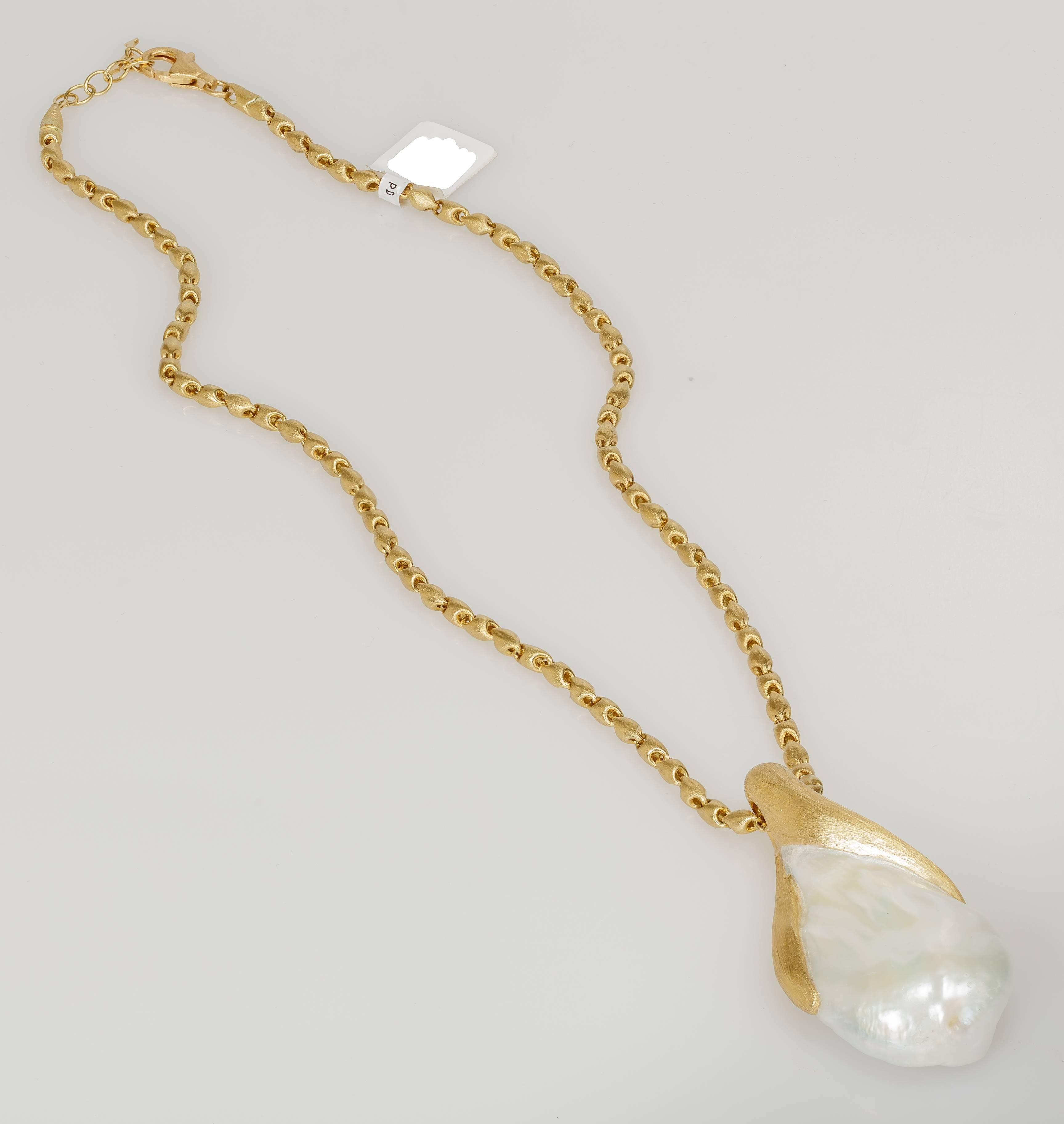 This Yvel necklace features a large white baroque pearl pendant set on a satin brushed 18k yellow gold 18 inch chain.