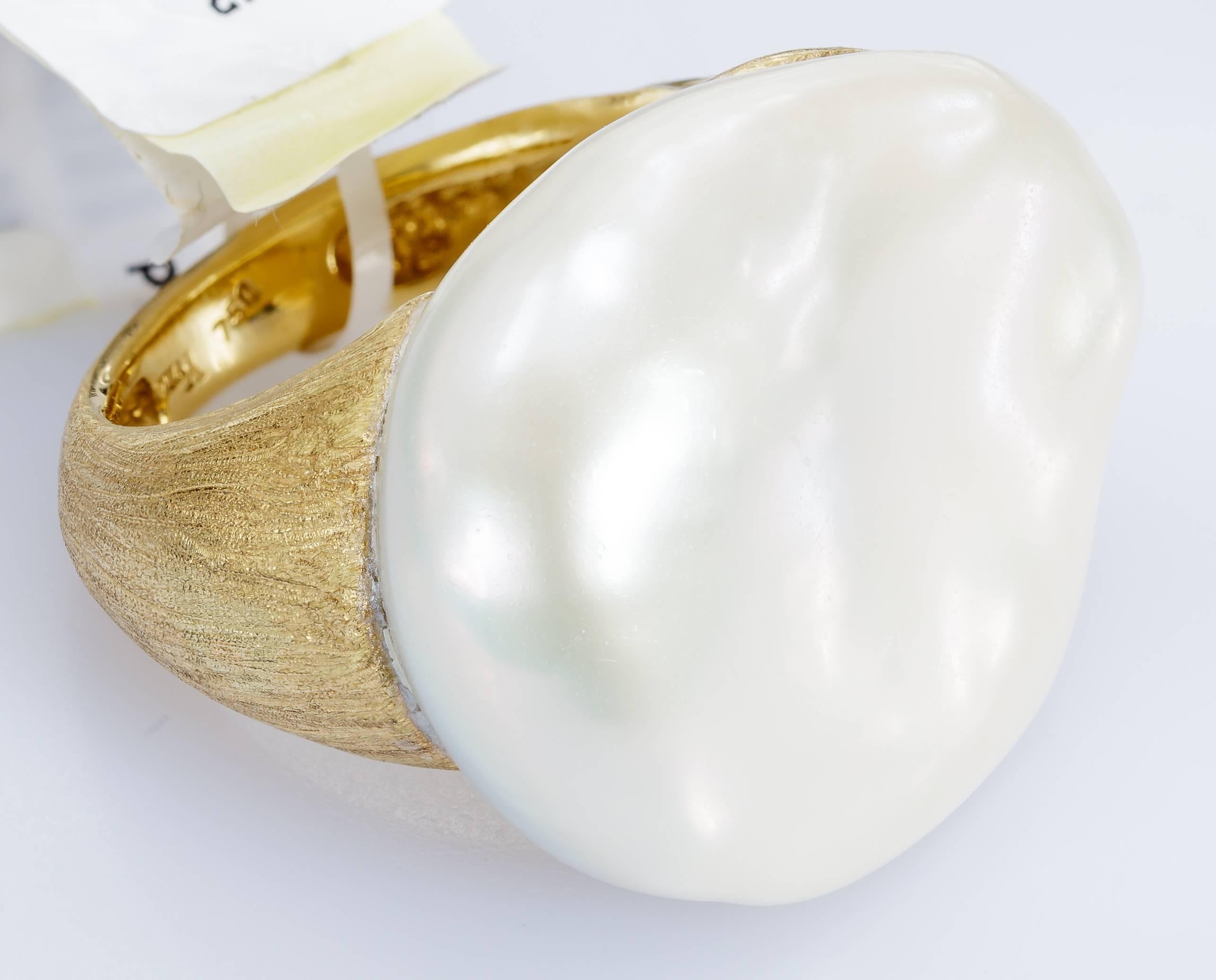 This Yvel ring features a white freshwater baroque pearl on a satin brushed 18k yellow gold band.  The ring is size 6.25. If you need this ring to be sized, please message us with your finger size. 