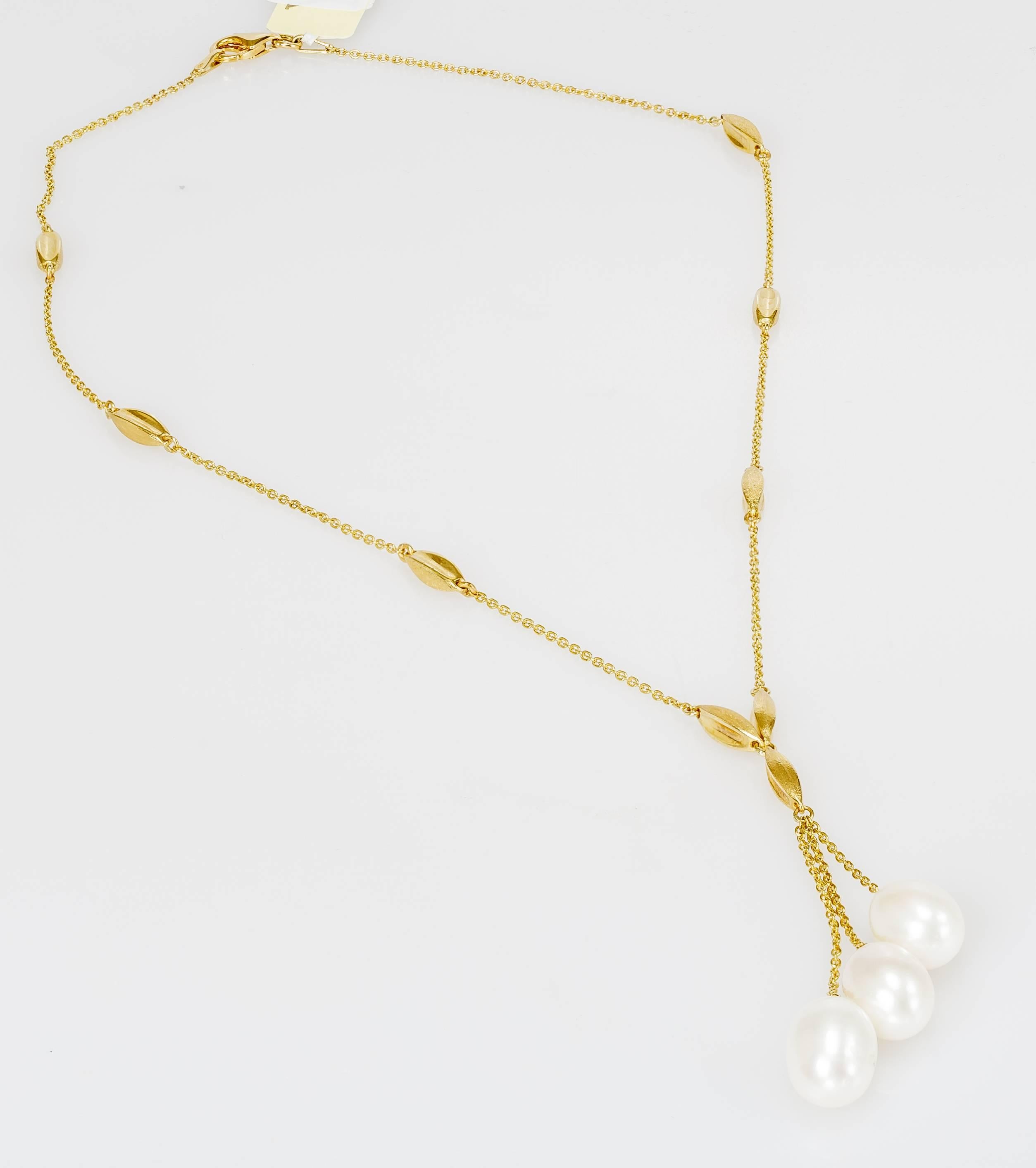 This Yvel drop necklace features three freshwater keshi pearls on an 18k yellow gold chain. The necklace measures 16 inches long. The pendant adds more length. 