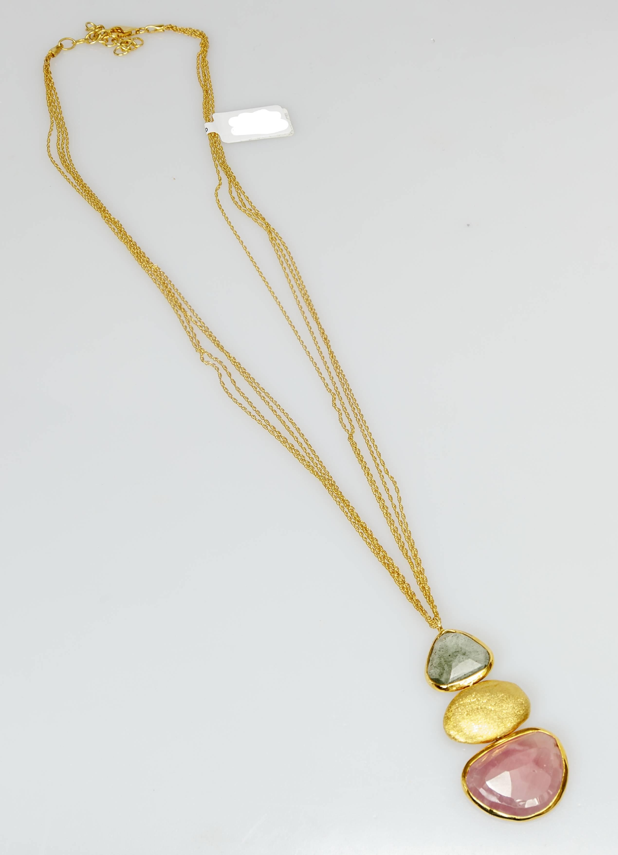 This Yvel pendant necklace features two faceted natural fancy colored sapphires on an 18k yellow gold chain.  The 18k yellow gold multi-strand chain measures 21 inches long.