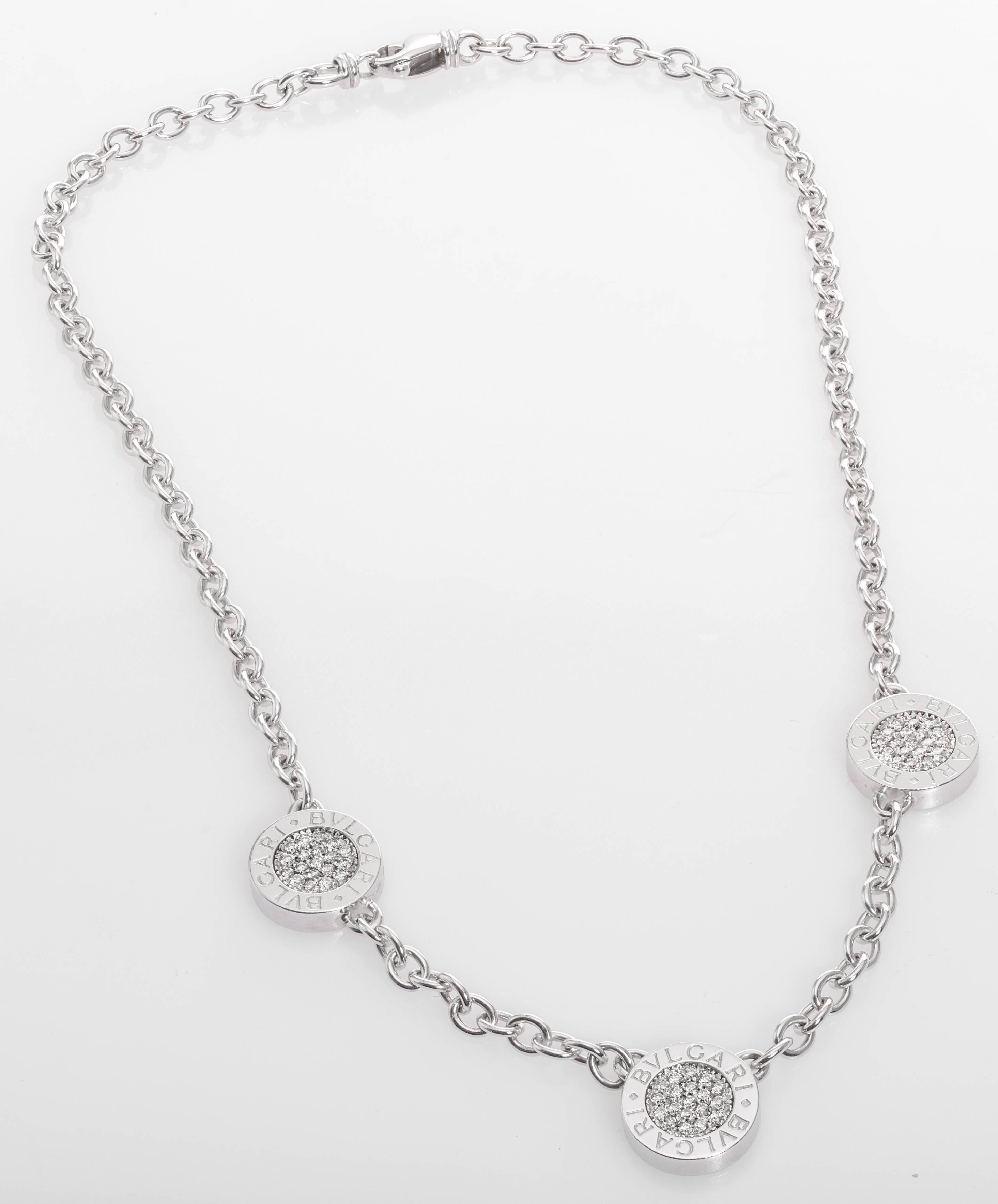 This Bulgari BVLGARI BVLGARI collection necklace has three charms with pavé-set round diamonds on one side and black onyx on the other. The necklace is 15.5" long and has a lobster clasp. 