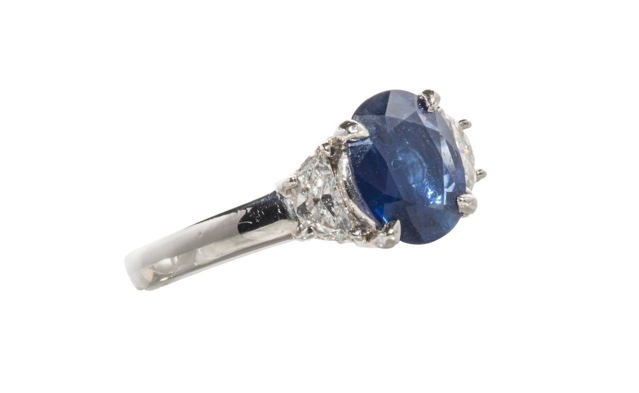 Lovely ring containing a blue sapphire weighing approximately 2-2.25 ct. and two diamonds totaling  approximately .50ct. set in platinum.  It is a size 6 1/2 but we can easily resize it.