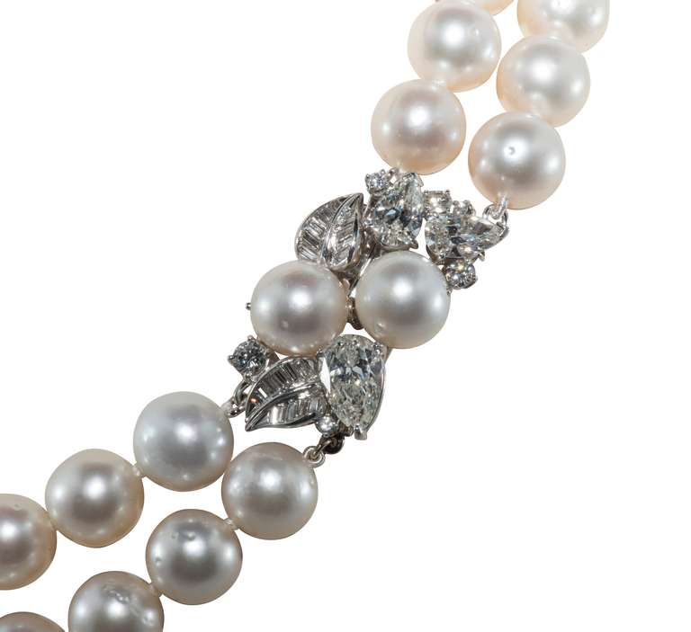 Double strand necklace of South Sea Pearls 10.0 mm - 11.0 mm with satiny luster.  The clasp is Platinum set with baguette diamond that for leaves and round and Pear-shaped diamonds 2=1.80 cts 1=1.70 cts and the rest total approximately 3.0 cts. 