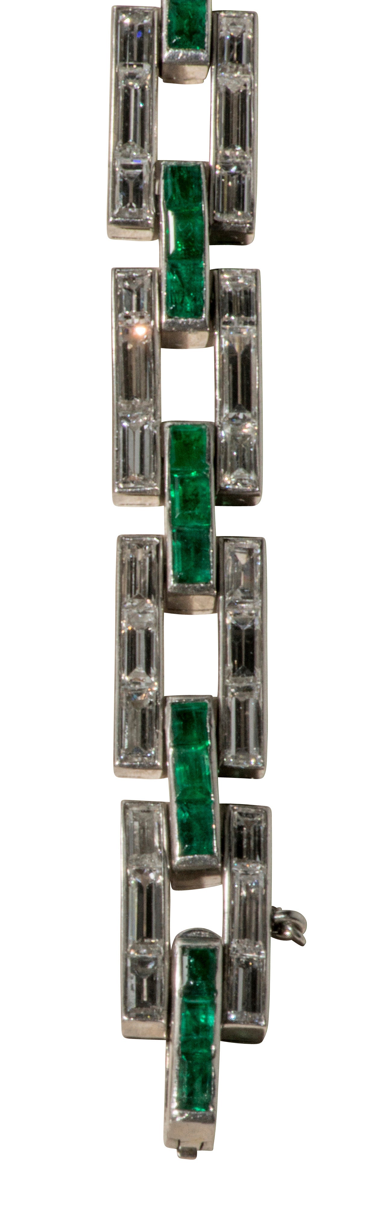 This is an elegant Cartier Art Deco diamond and emerald geometric link bracelet set in platinum from the 1920's. The bracelet is signed on the clasp.