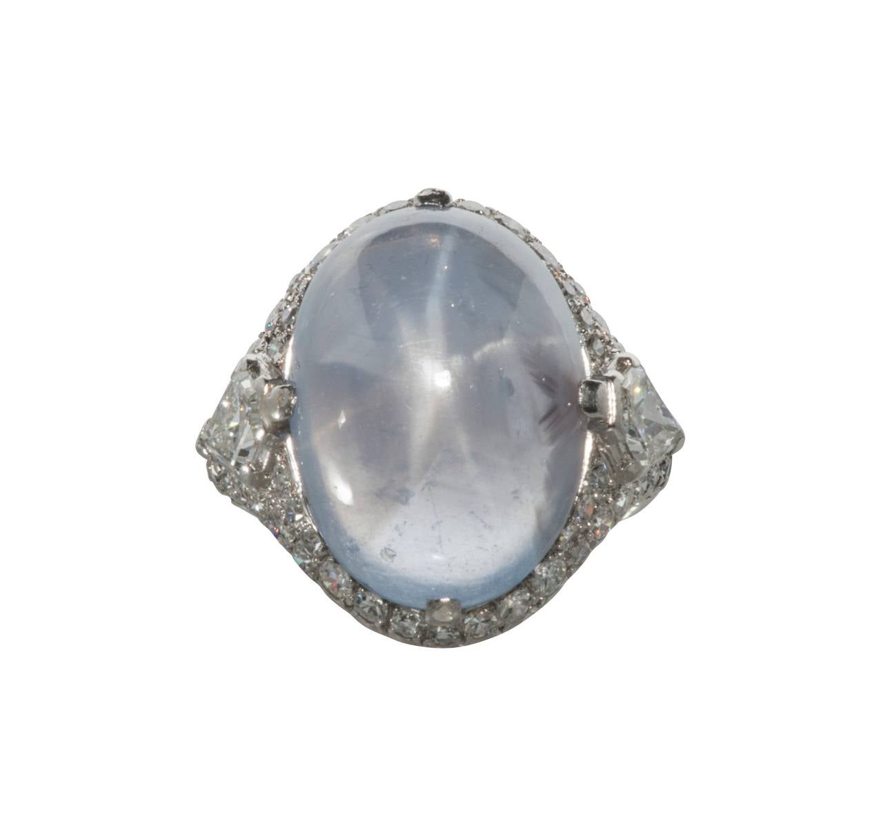 This is a striking star sapphire set in platinum with diamonds.  It is fitted with a fingermate adjustable shank. When closed it is a size 5. Unfortunately the photographs do not do the star in the sapphire justice. The color is bluish, lavender,