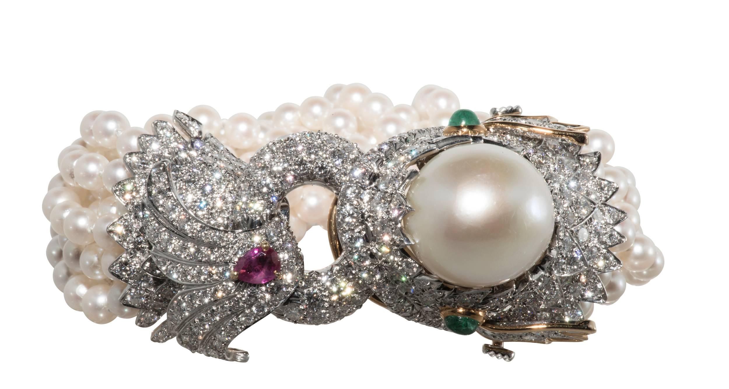 This is an exquisite David Webb 'Dolphin' bracelet containing 11.91ct of diamonds, pear shaped ruby weighing .57cts, 2 cabochon emeralds weighing .66cts. and 1 South Sea pearl and12 strands of 5-51/2 mm pearls all set in 18k yellow gold and platinum.