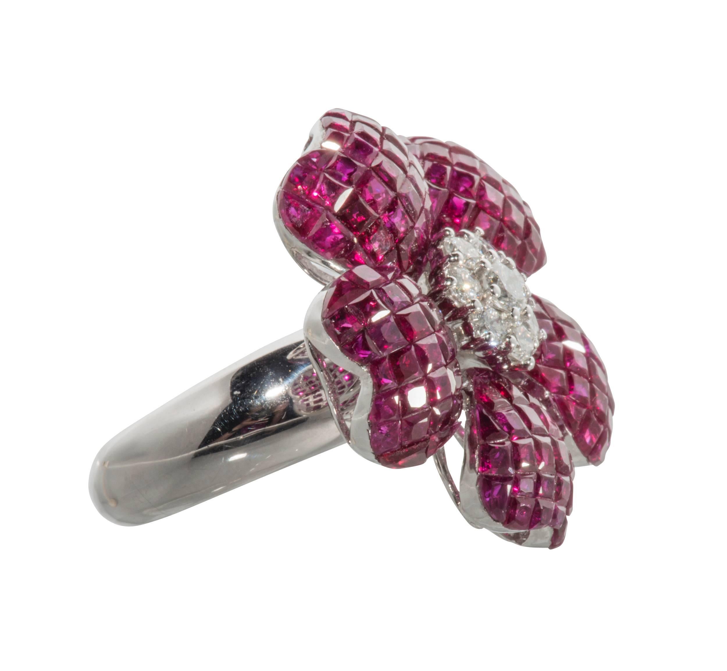 This is a lovely flower design ring with invisibly set rubies and diamonds set in 18k white gold.  These are Burmese and have been heat treated. It is a size 7 but we  can easily be resized.