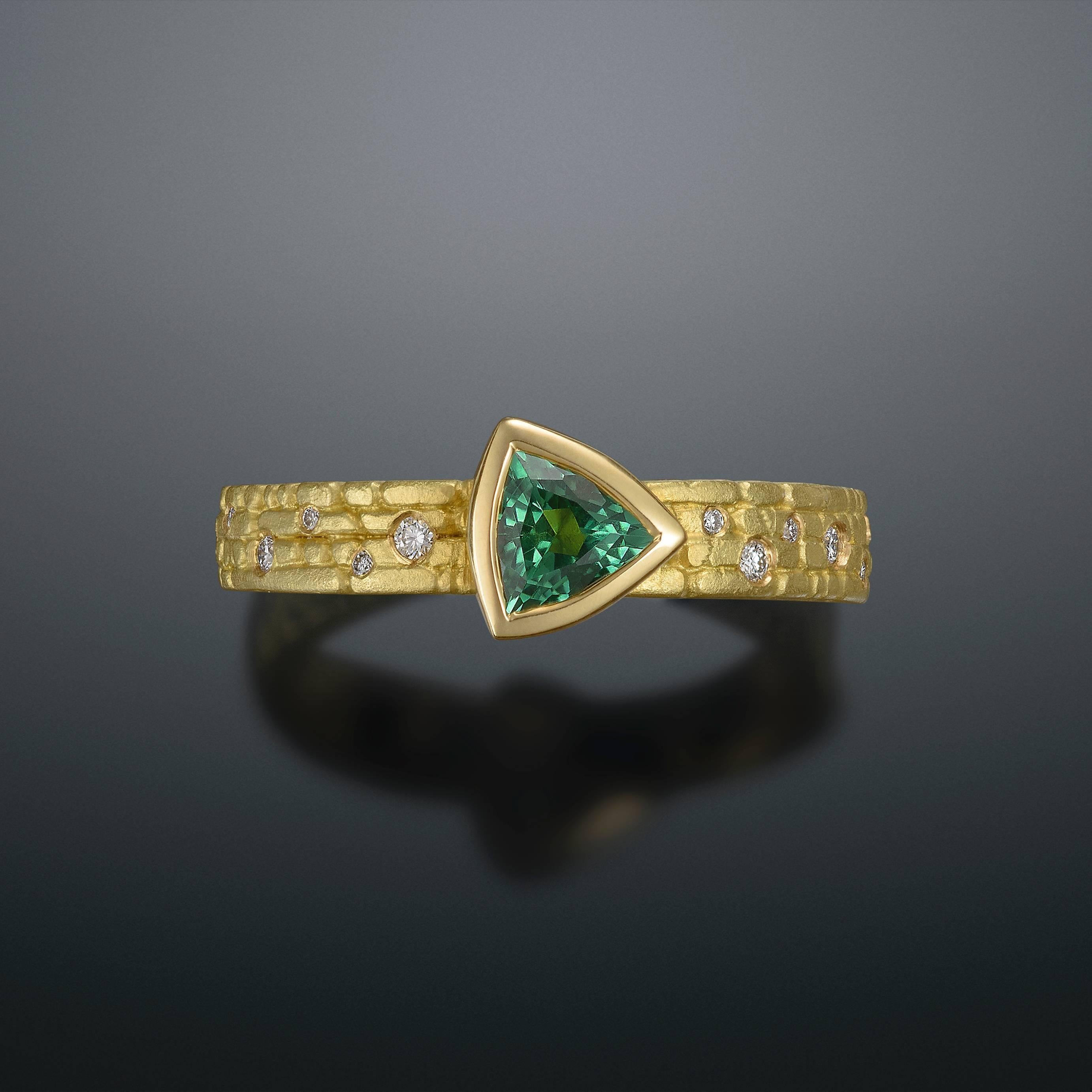 18kt cobbled Gold ring with blue-green Trillion Usakos Tourmaline and diamonds.

Ring is size 6.5, but can be resized.

* Each piece is designed and crafted entirely by hand in the traditional way, using age old techniques and processes.