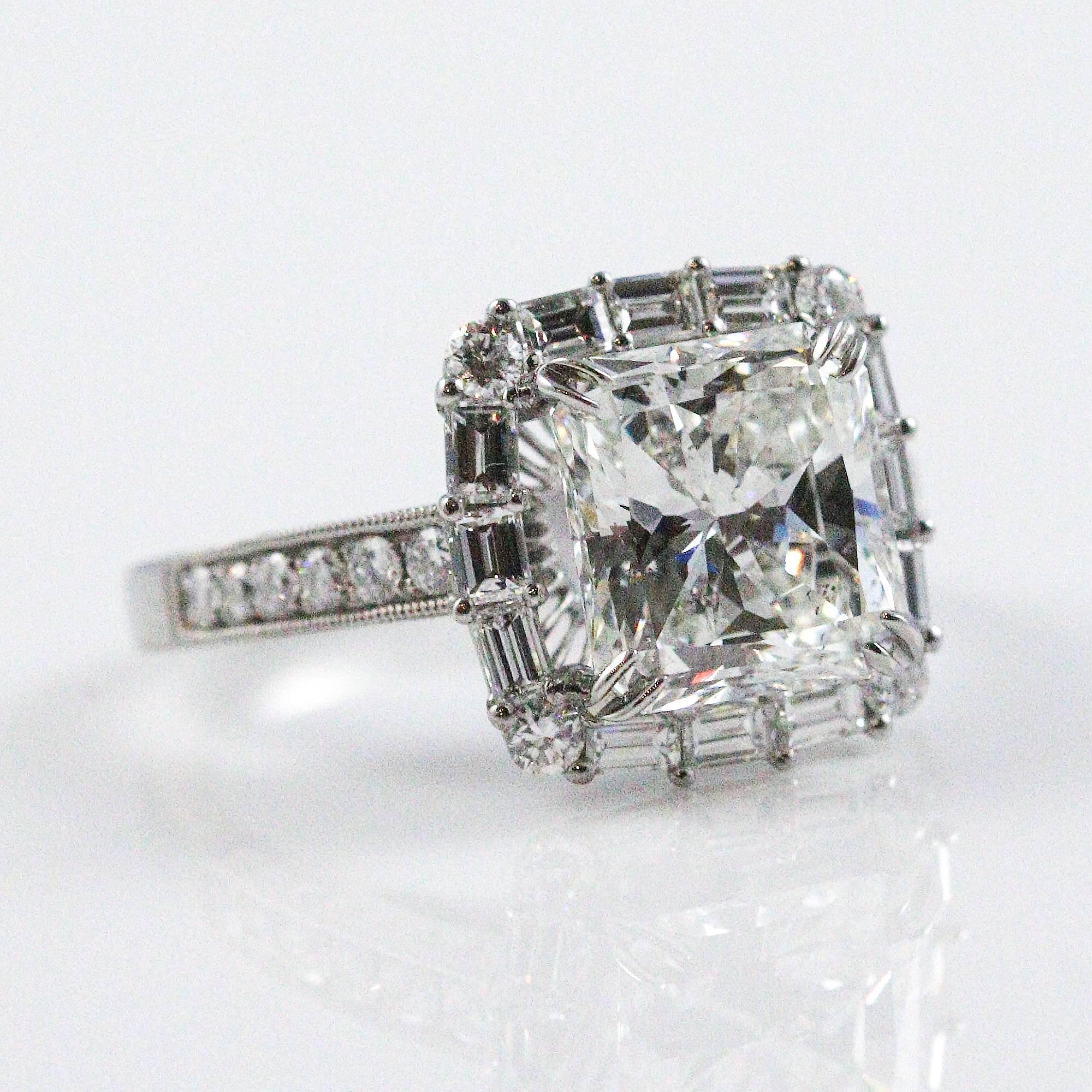 This beautiful ring centers a stunning center diamond and a very unique halo made up of baguette and round cut diamonds. The center stone weighs 3.09ct, measures 9.03 x 8.57 x 5.25 mm and grades as 