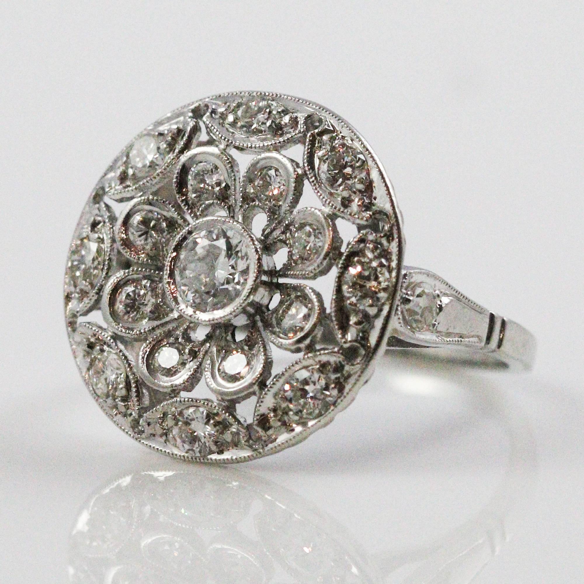 This gorgeous ring is the epitome of Art Deco design: elaborate, elegant, functional, feminine and bold. It is made in platinum with a center European cut diamond weighing approximately 0.26ctw and grading as 