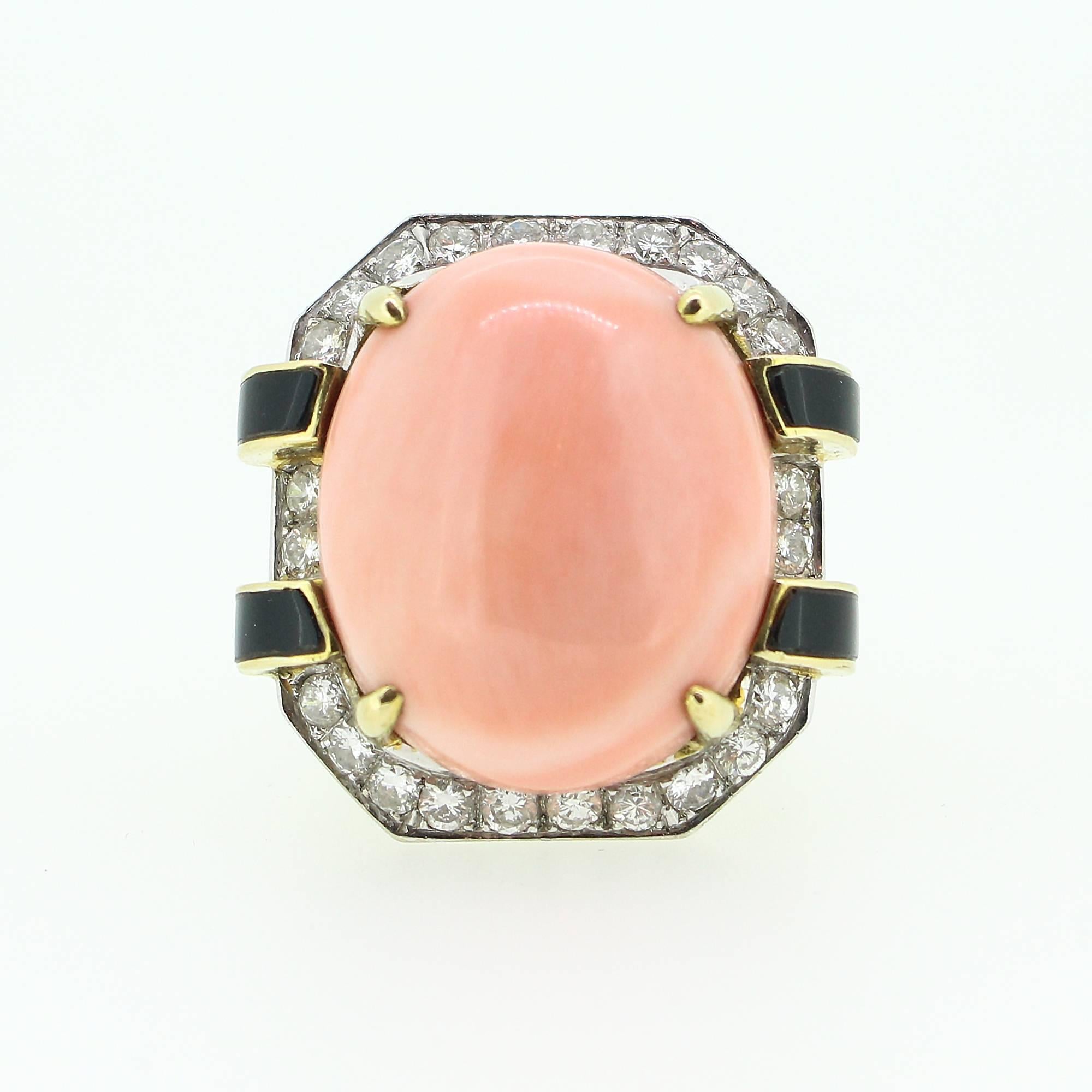 This beautifully made ring centers a 23.6 x 19.6 mm cabochon cut piece of coral set in yellow gold and accented by 4 pieces of black onyx and 24 round brilliant cut diamonds (1.44ctw apx, 