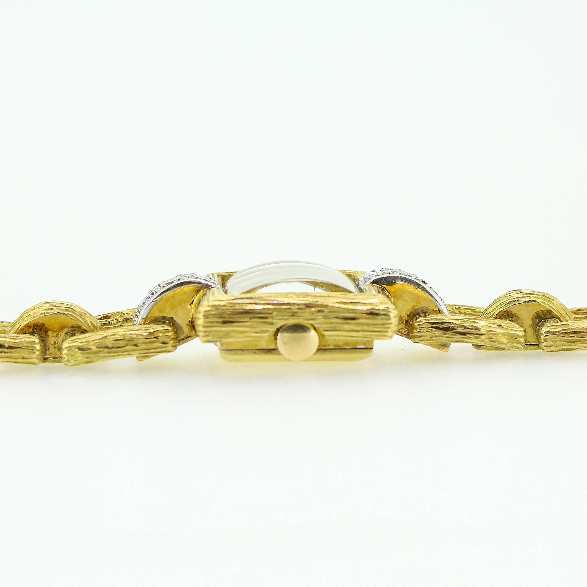 Diese modernistische Armbanduhr aus den 1960er- und 1970er-Jahren ist aus 18 Karat Gelbgold gefertigt und mit einer rindenartigen Struktur versehen:: die den Diamanten an beiden Enden des Zifferblatts zur Geltung bringt. Das 17-steinige Uhrwerk ist