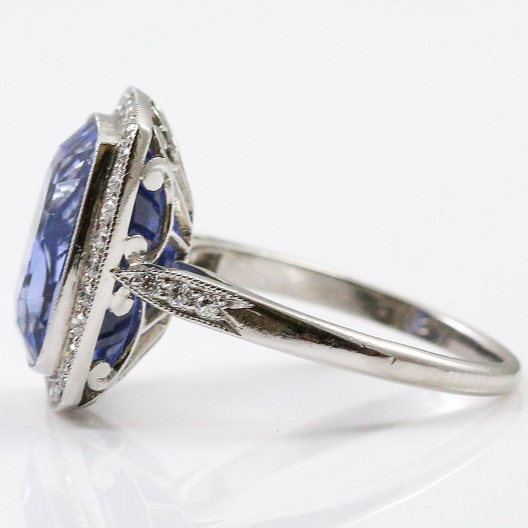 This jaw dropping cushion cut blue sapphire comes with an AGL report that indicates it comes from Ceylon and has no heat treatment. The giant cushion cut sapphire is bezel set in platinum and surrounded by a halo of 32 round brilliant cut diamonds