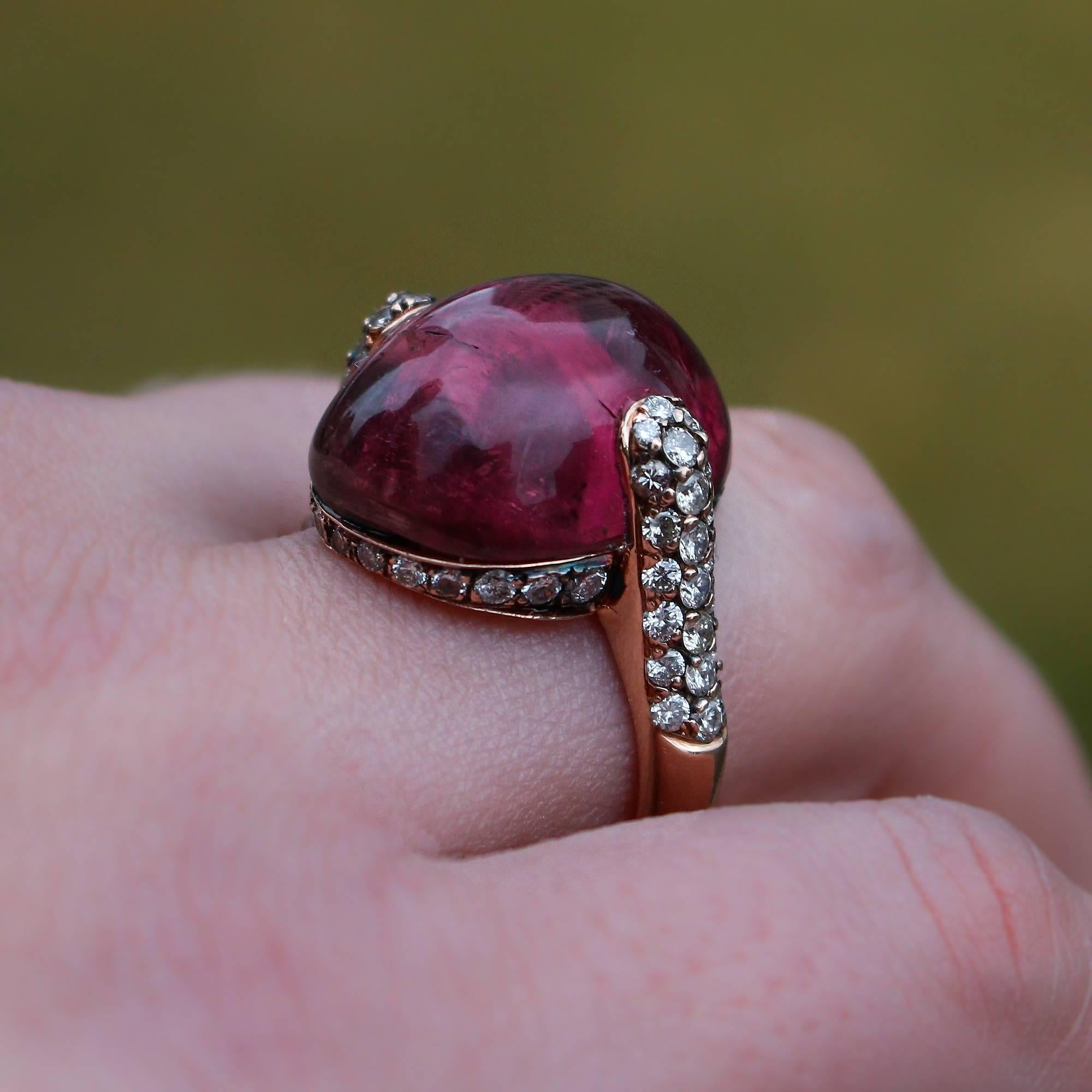 Cette magnifique bague est centrée sur une tourmaline rubellite massive taillée en cabochon qui pèse environ 16::00 ct. La pierre centrale comporte quelques belles inclusions qui ajoutent à la vie de la pierre et n'affectent pas son intégrité. La