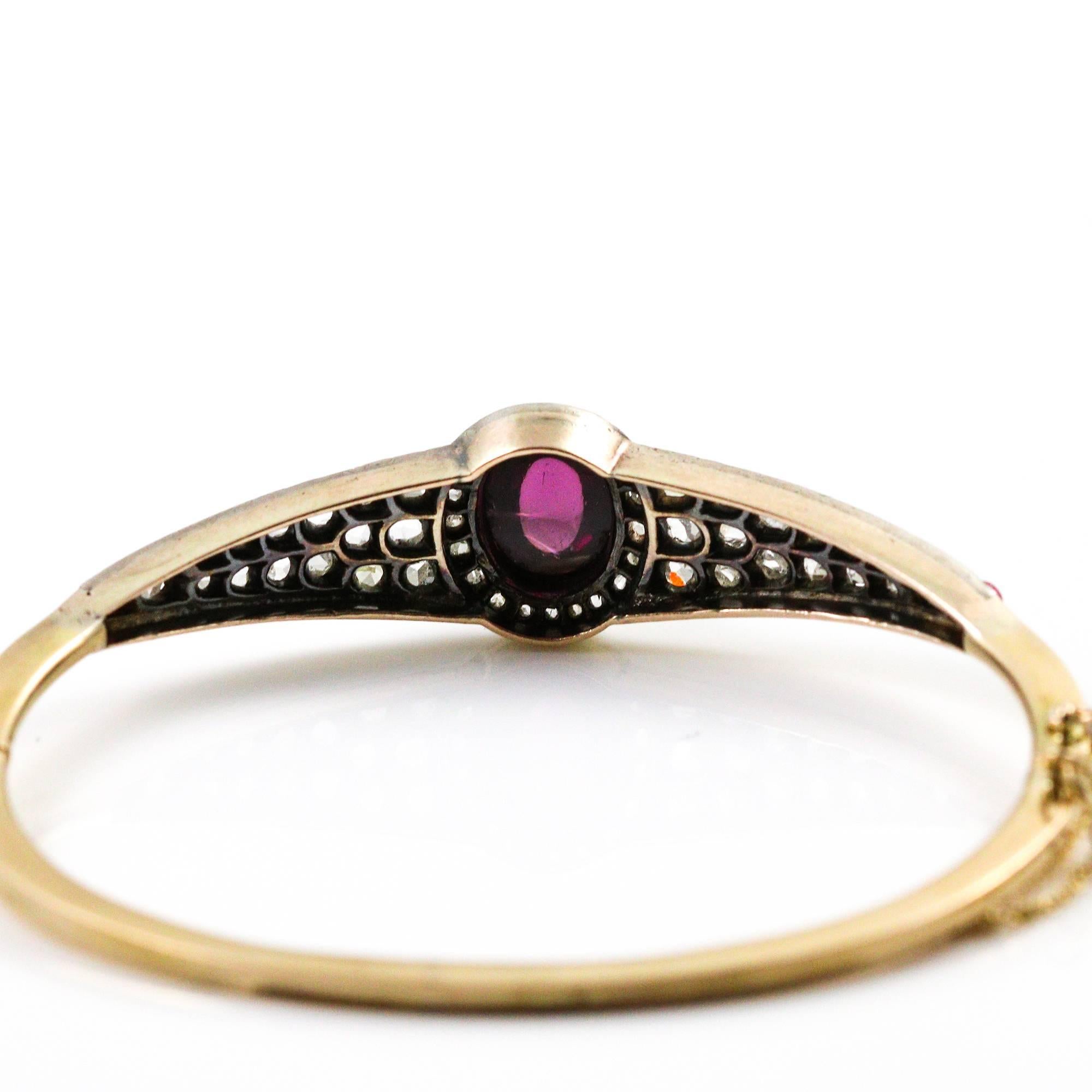 This early Victorian bracelet centers a cabochon cut rubelite tourmaline which measures 10.75 x 8.55 mm. It is accented by a halo of 21 old rose cut diamonds and a design made up of 15 old rose cut diamonds and 1 small cabochon rubelite tourmaline