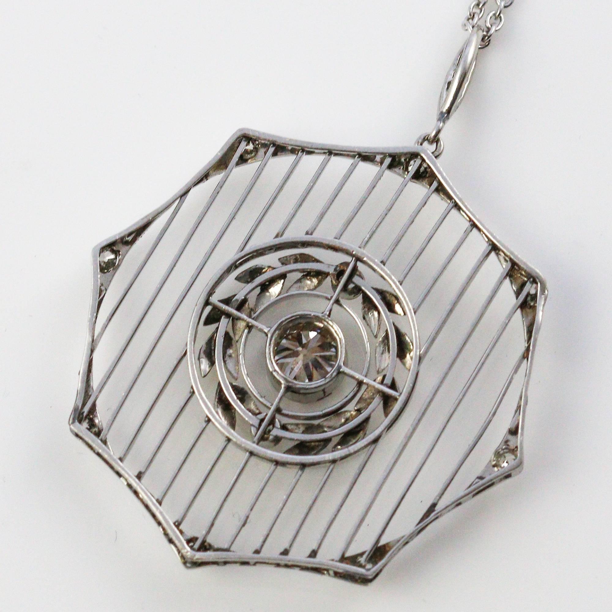 The center stone of this unique pendant is an old mine cut, which weighs approximately 0.45ct and grades as 