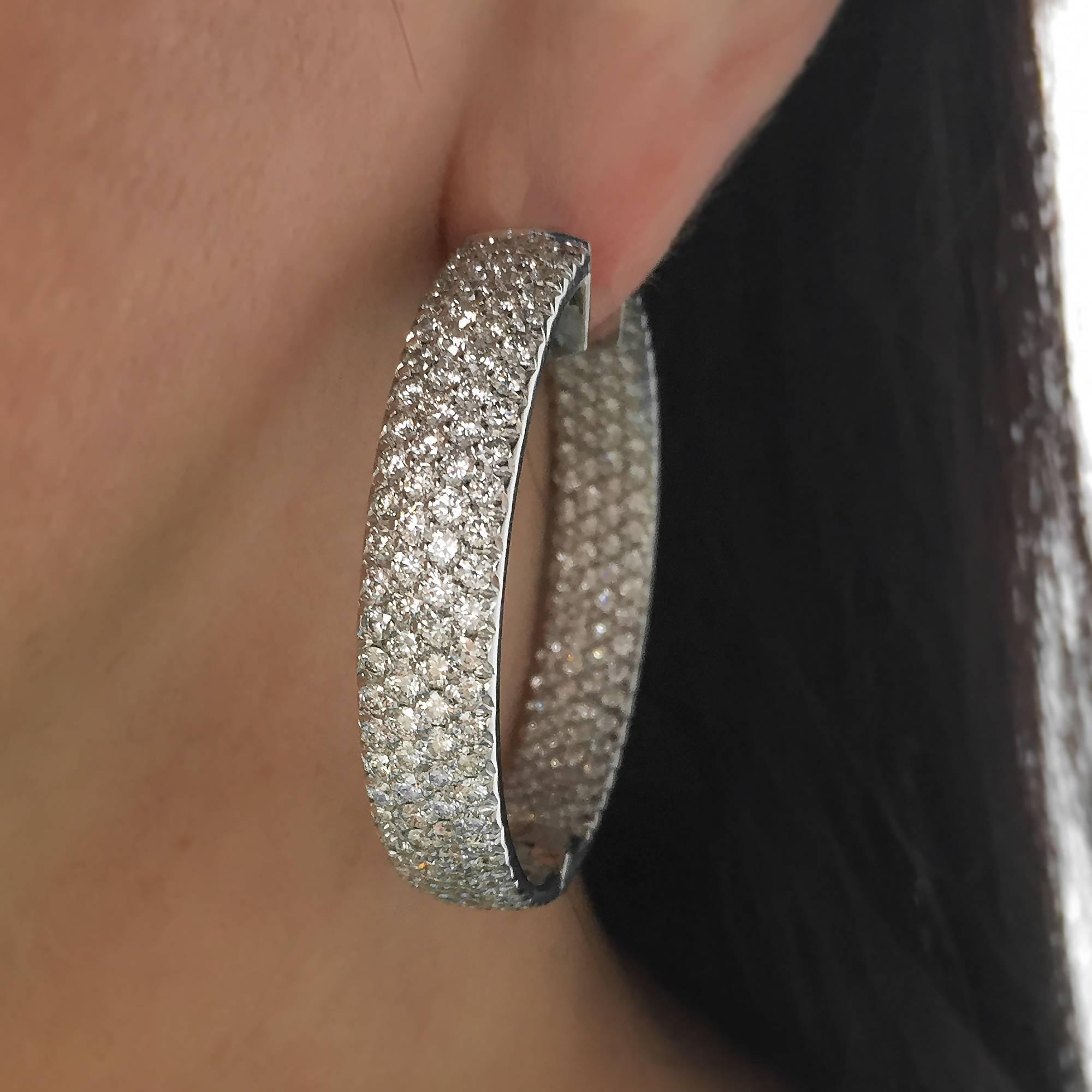 These gorgeous inside out hoop earrings feature a total of 396 pave set round brilliant cut diamonds, which are estimated to weigh 10.00ctw and grade as G-H in color and VS in clarity on a GIA diamond grading scale. The stones are set in 18k white