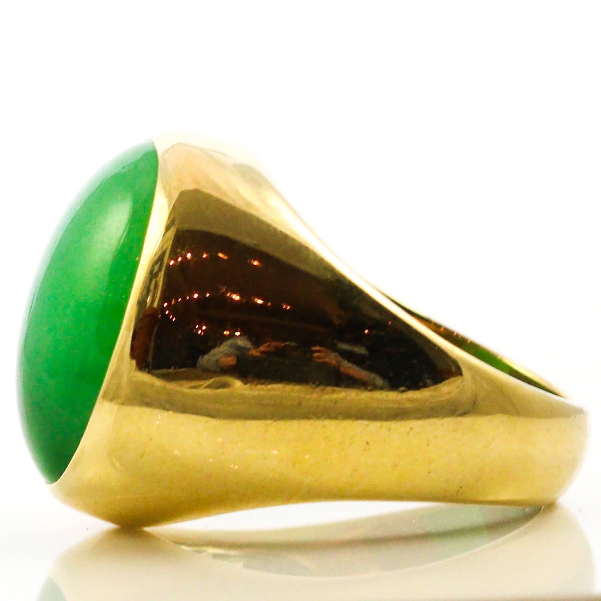This phenomenal ring centers a 20.15 x 15.45 x 7.00 mm piece of oval cabochon cut jadeite jade set in an 18k yellow gold setting. The piece comes with a report from Mason-Kay Jade Laboratory indicating that the stone is natural grade "A"