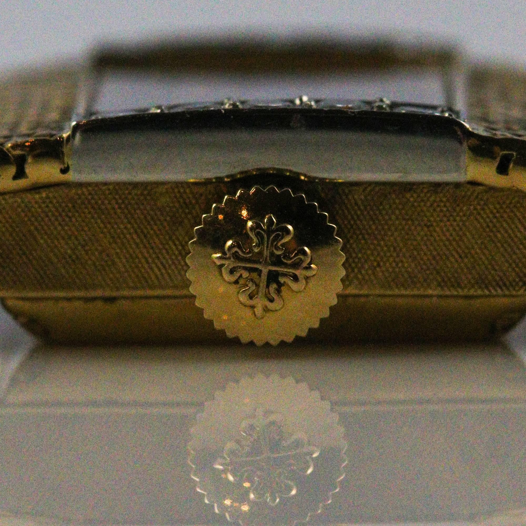 This beautiful yellow gold watch is made in a collaboration between Patek Philippe and Tiffany & Co. The case and band are 18k yellow gold with a white face and 8 round diamonds on the lining the side of the dial. The diamonds weigh an estimated