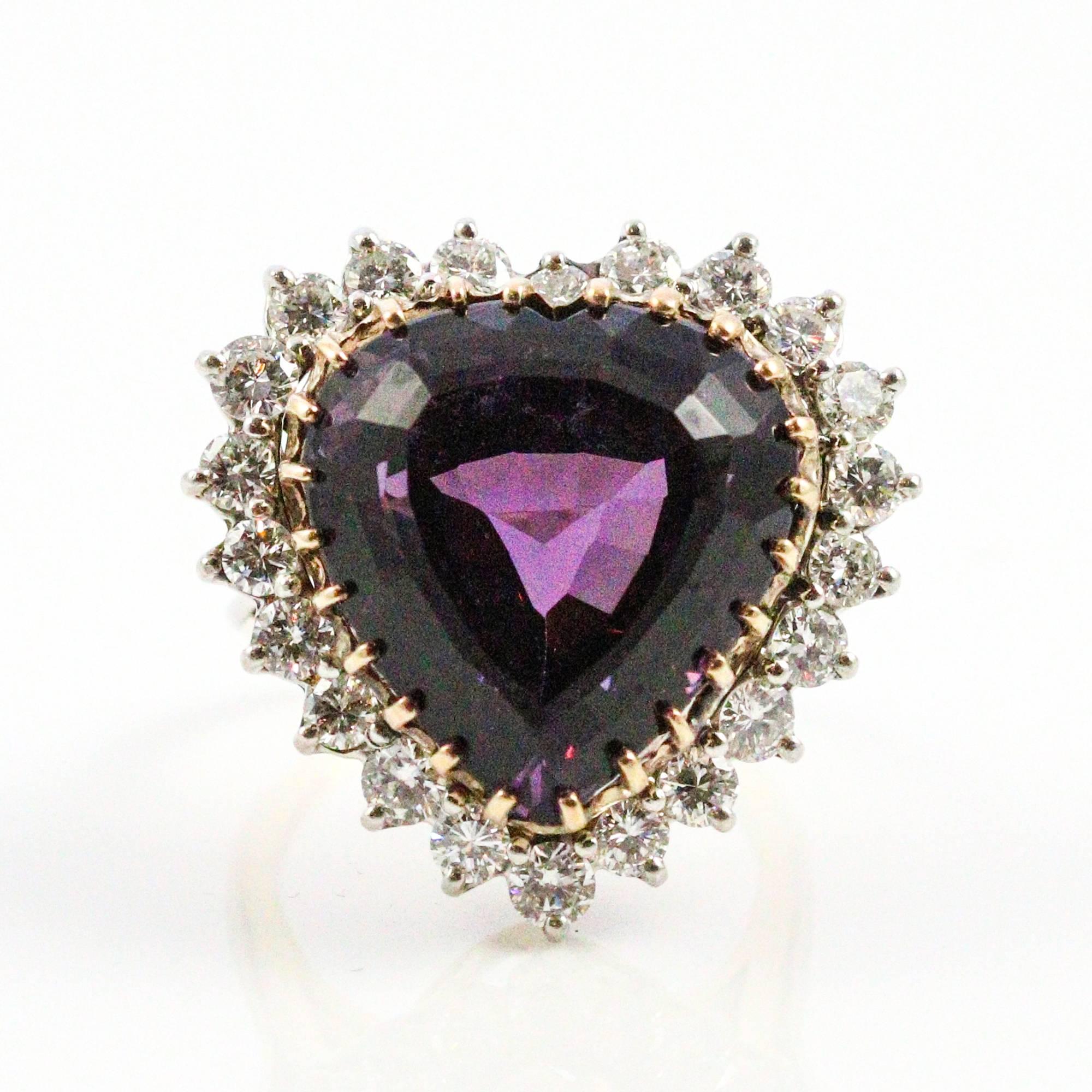 This show-stopping ring centers a heart shaped amethyst, which measures 19 x 13mm and weighs approximately 12 carats. The stone is set in 14k yellow gold with a halo of 22 round brilliant cut diamonds set in white. The diamond weigh approximately 2.