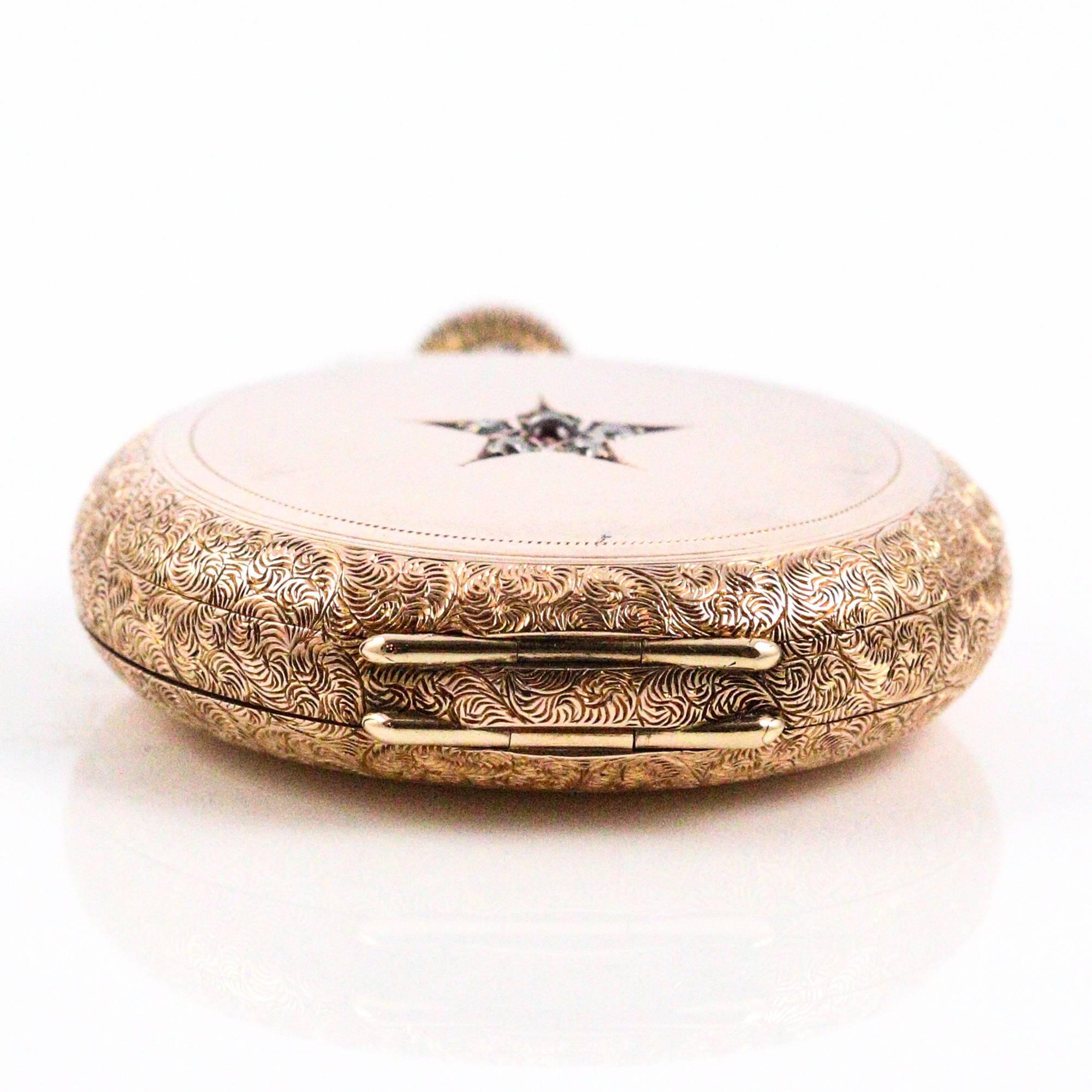This 14k rose gold Elgin pocket watch features an elegantly engraved hunter's case and a back case decorated with 5 small mine cut diamonds (0.25ctw apx) and 1 small cabochon ruby. The inside back case is engraved with the name "Flora