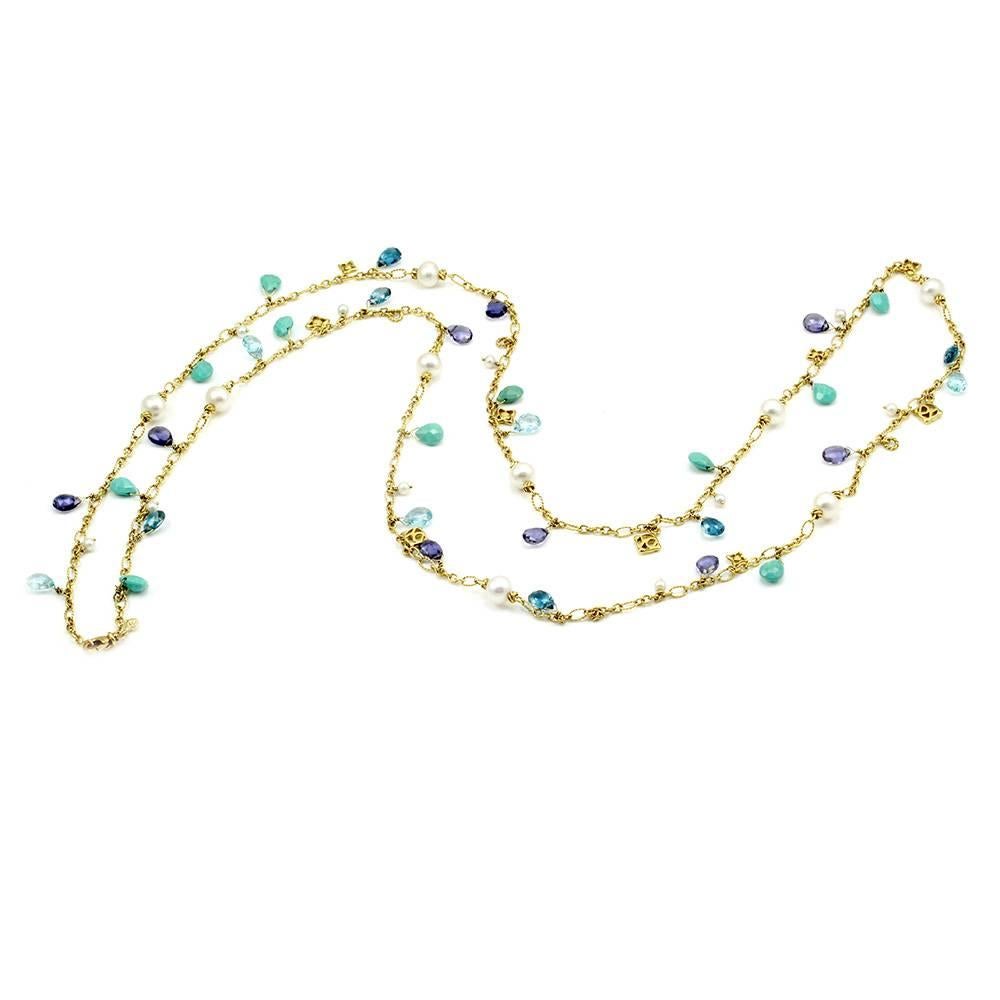 Signed designer David Yurman Bijoux collection opera length necklace in high polished 18K yellow gold. There are ten blue topaz, nine iolite, and eleven turquoise. The gems are all briolette cut. There are nineteen round, white pearls measuring