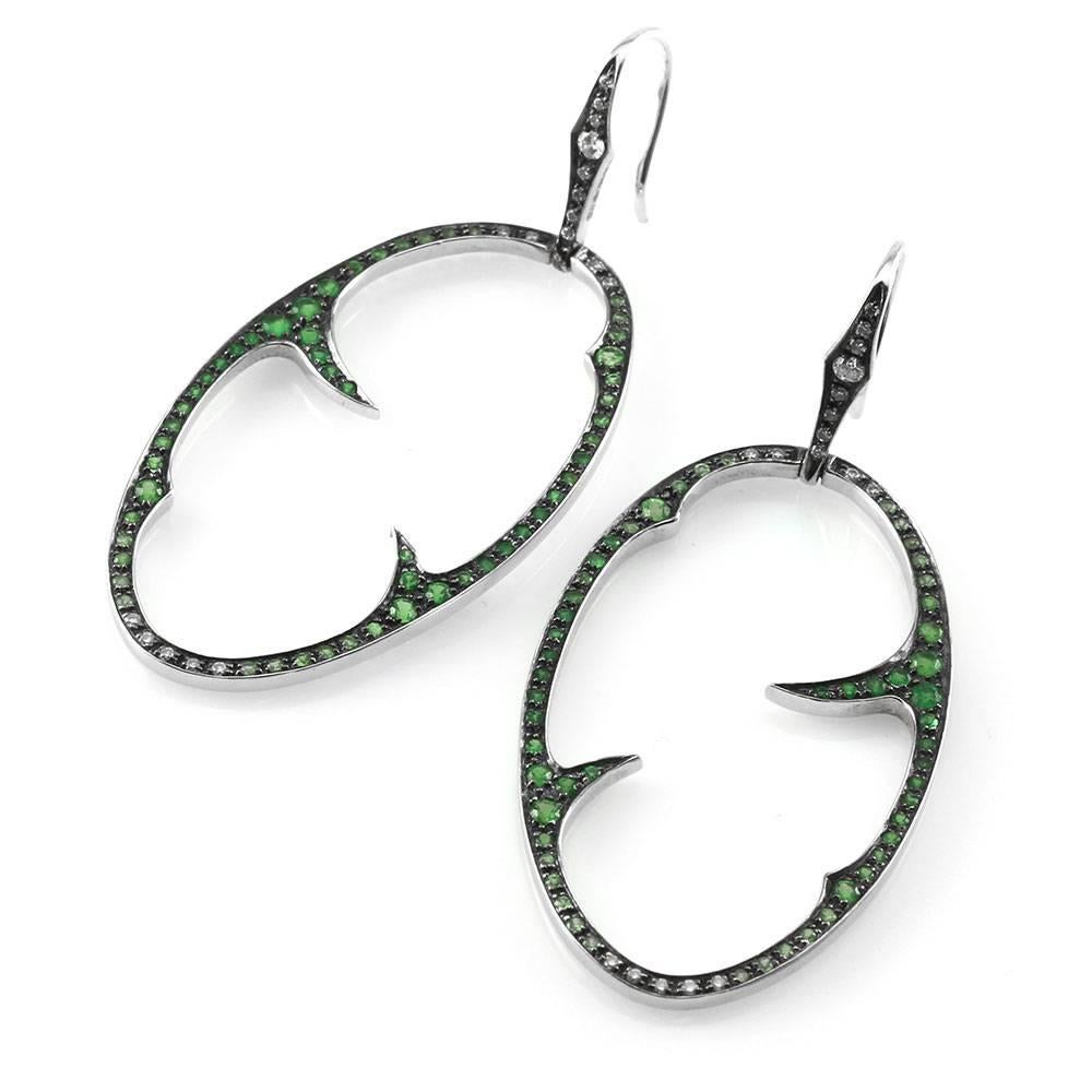 Signed designer Stephen Webster Thorn collection pavé diamond and tsavorite garnet earrings set in 18K white gold. There are one hundred eight round faceted tsavorite garnets (0.70ctw) and thirty-four round brilliant cut diamonds (0.21ctw) with a