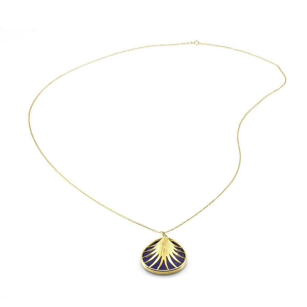 Signed designer Tiffany & Co. Villa Paloma palm necklace with lapis lazuli set in 18K yellow gold. There is one pear shaped lapis lazuli insert (37.5mm x 30.0mm) that is bezel set in an open frame of high polish 18K yellow gold. The bail opening is