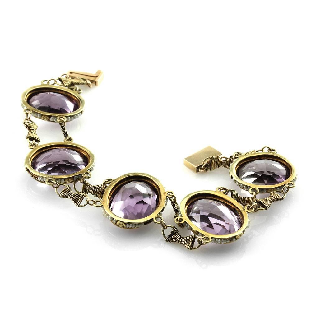 Antique Victorian amethyst seed pearl halo station bracelet set in 14K yellow gold. There are five oval faceted amethyst (60.00ctw) and the seed pearls are 1.5mm. The amethyst are bezel set and the pearls are strung on gold wire, both in 14K yellow