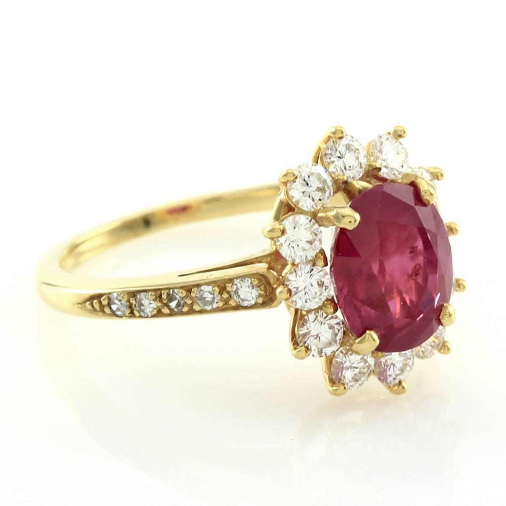 Tiffany & Co. Burmese ruby and diamond halo ring with pavé diamond accents set in 18K yellow gold. There are one oval faceted natural unheat treated Burmese ruby (2.32ct) and eight round single cut and fourteen round brilliant cut diamonds total