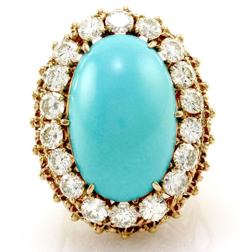 Vintage Persian Turquoise cabochon diamond halo ring set in 14K yellow gold. There are one oval turquoise cabochon (19.07ctw) and eighteen round brilliant cut diamonds (3.60ctw) with a color of H-I and a clarity of VS. The turquoise is claw prong